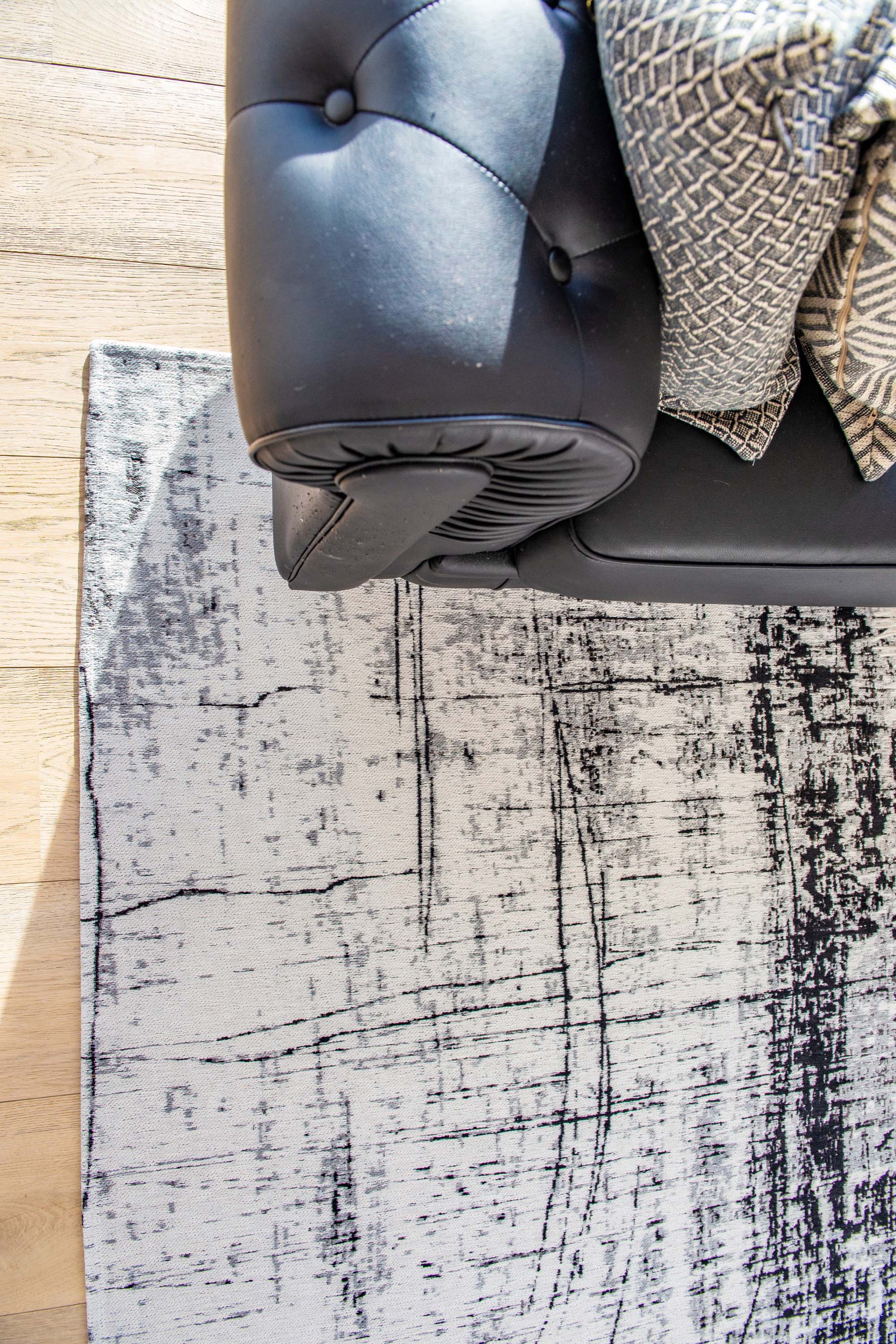 White flatweave rug with grey and black abstract pattern
