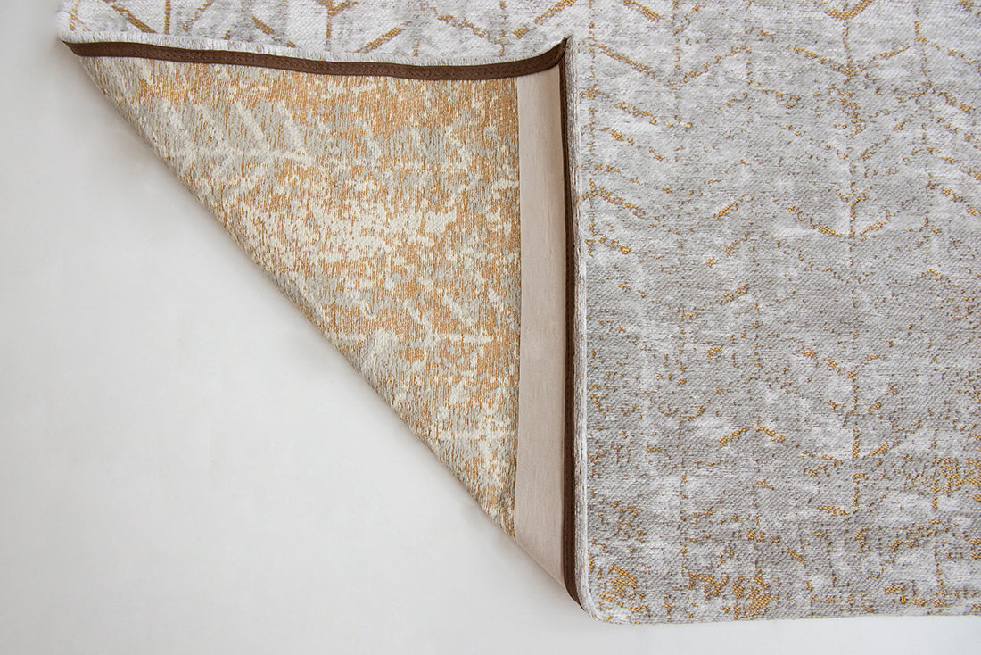 White flatweave rug with faded yellow chevron pattern