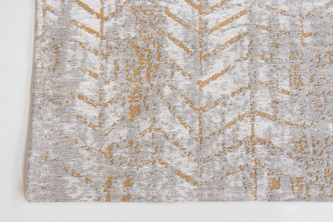 White flatweave rug with faded yellow chevron pattern