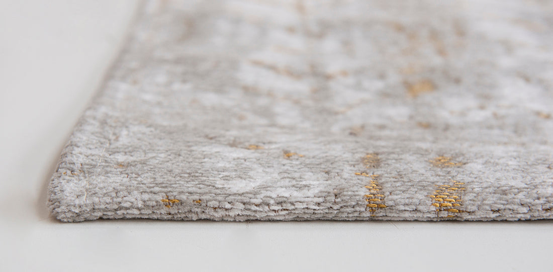 White flatweave rug with faded yellow chevron pattern
