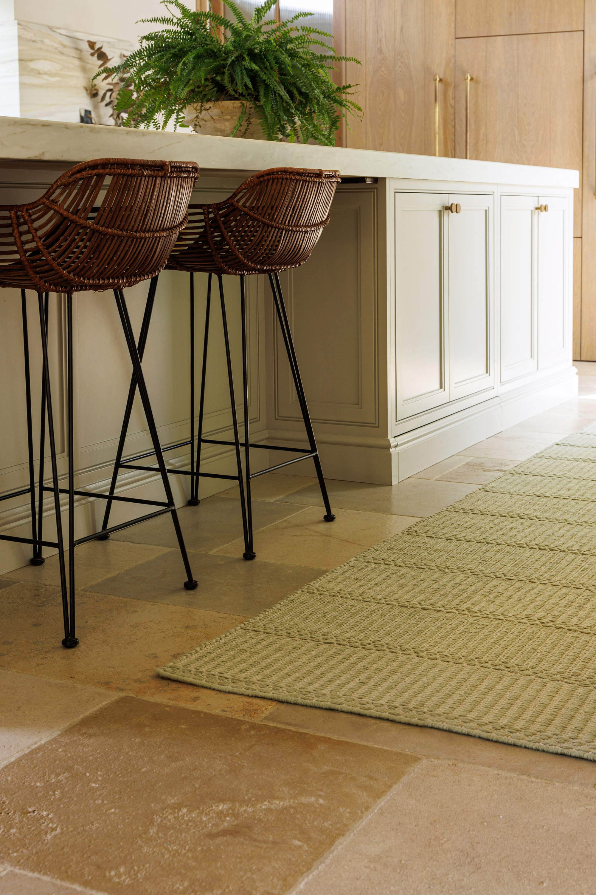 wool and cotton runner rug in soft olive hues featuring a design inspired by ancient irish script placed in a kitchen