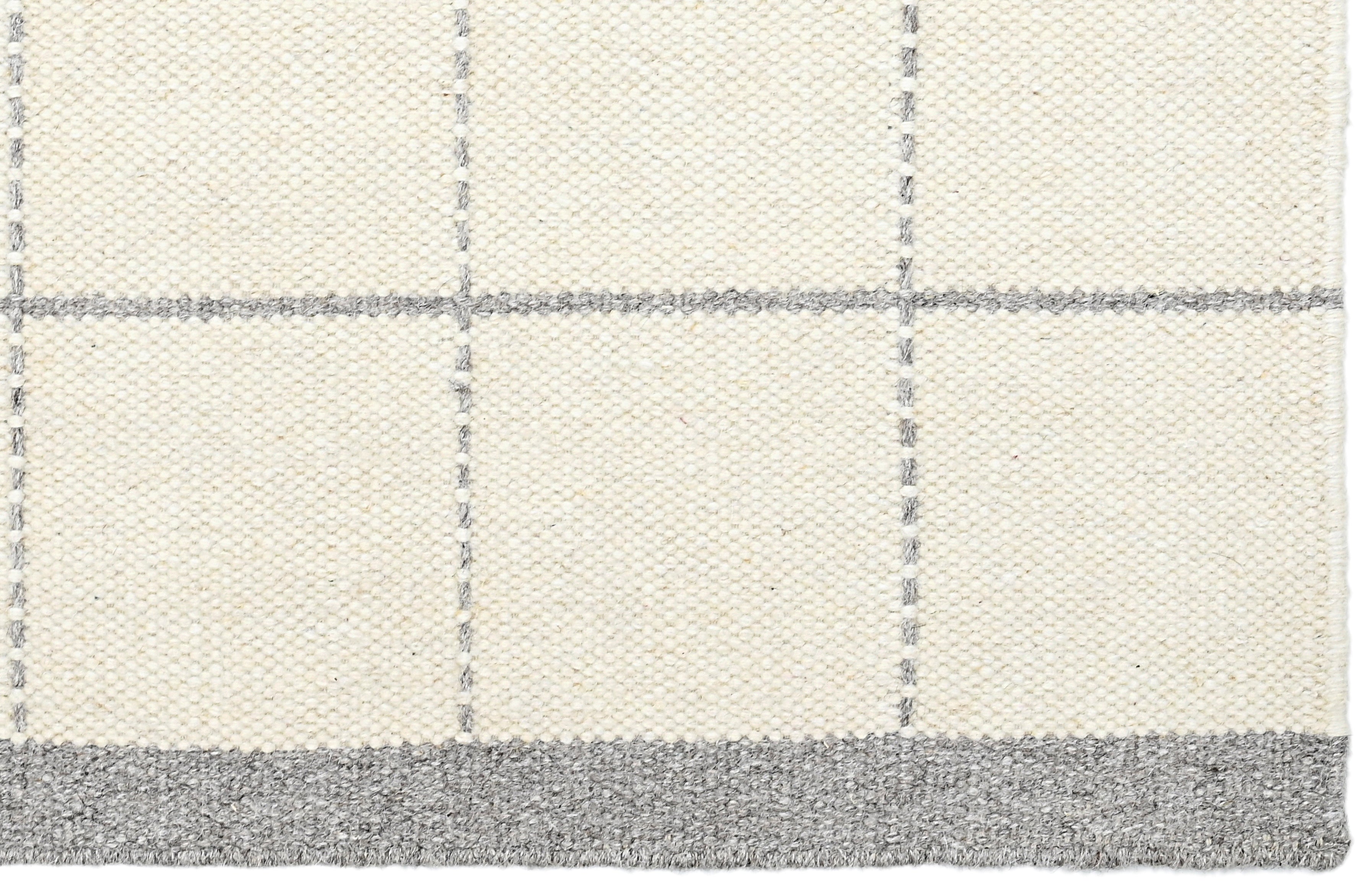 White wool and cotton area rug with grey checkered design