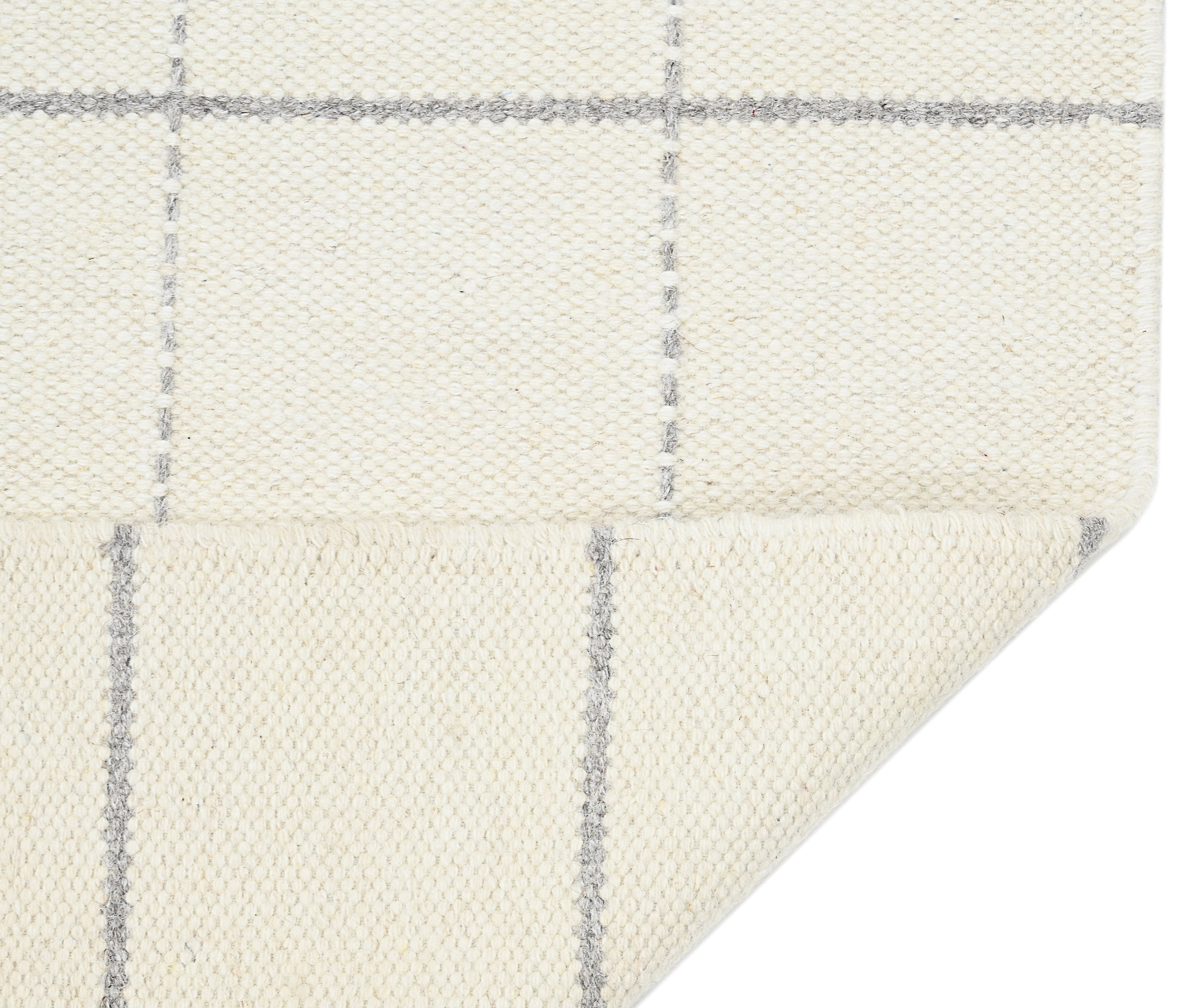 White wool and cotton area rug with grey checkered design