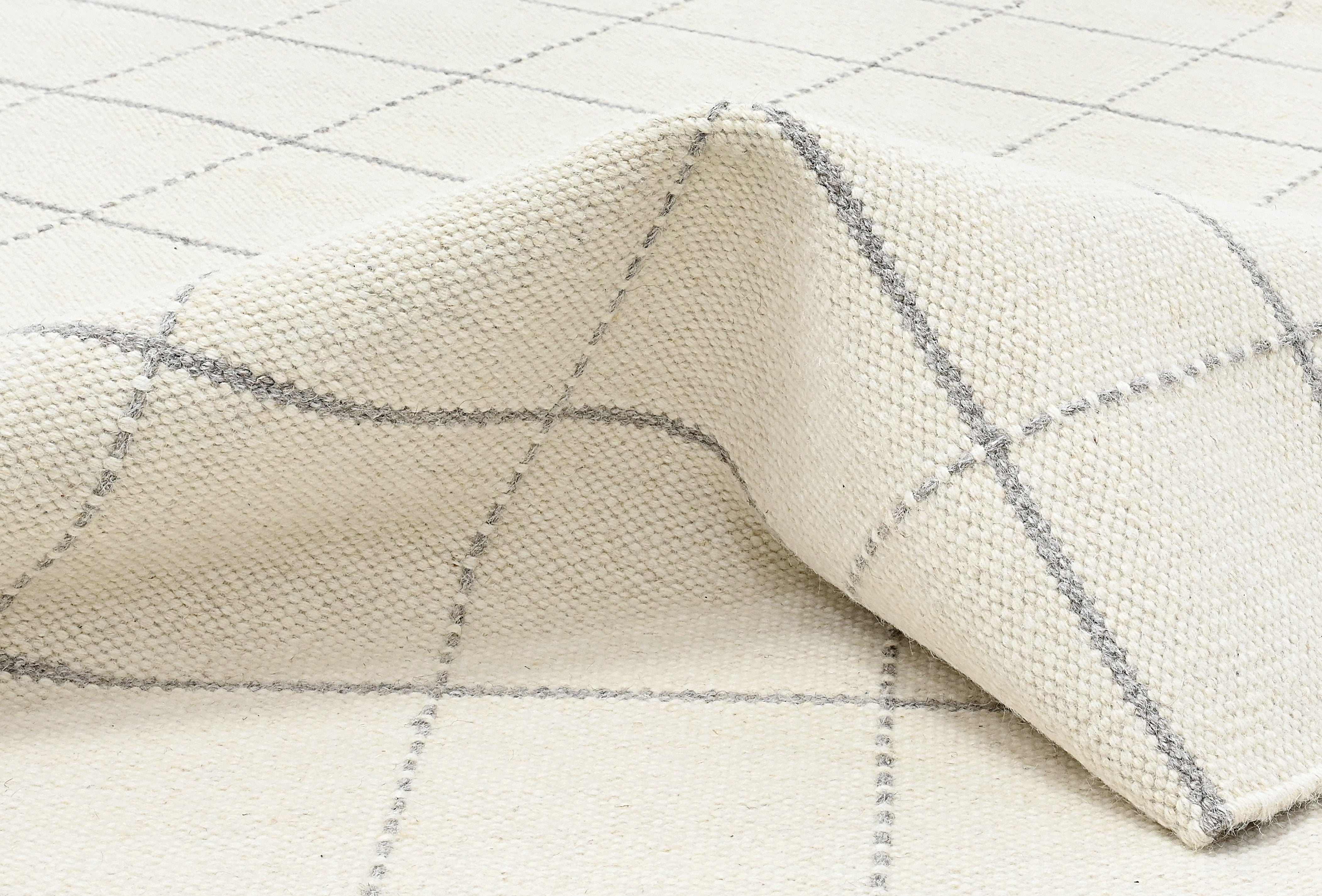 White wool and cotton area rug with grey checkered design