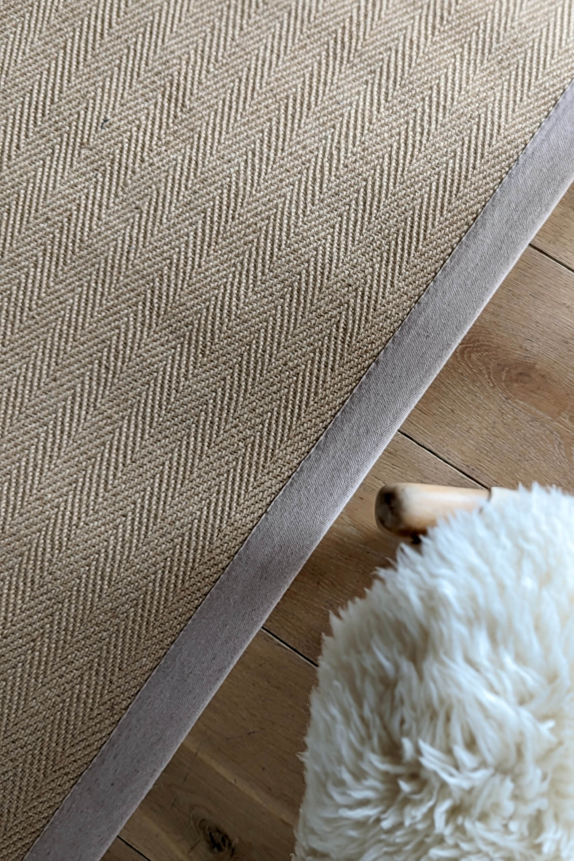 Sisal rug with herringbone pattern and beige linen border