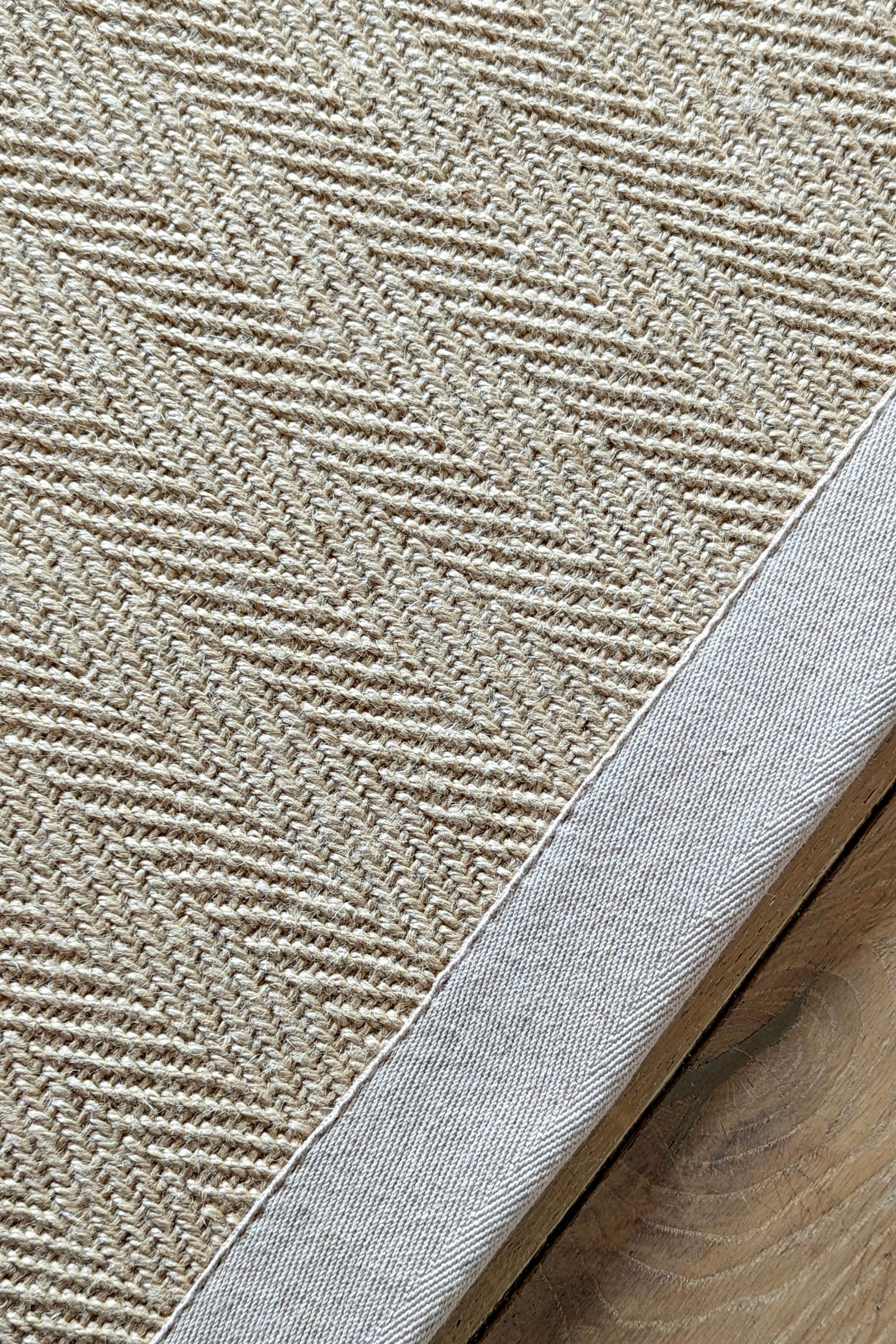 Sisal rug with herringbone pattern and beige linen border