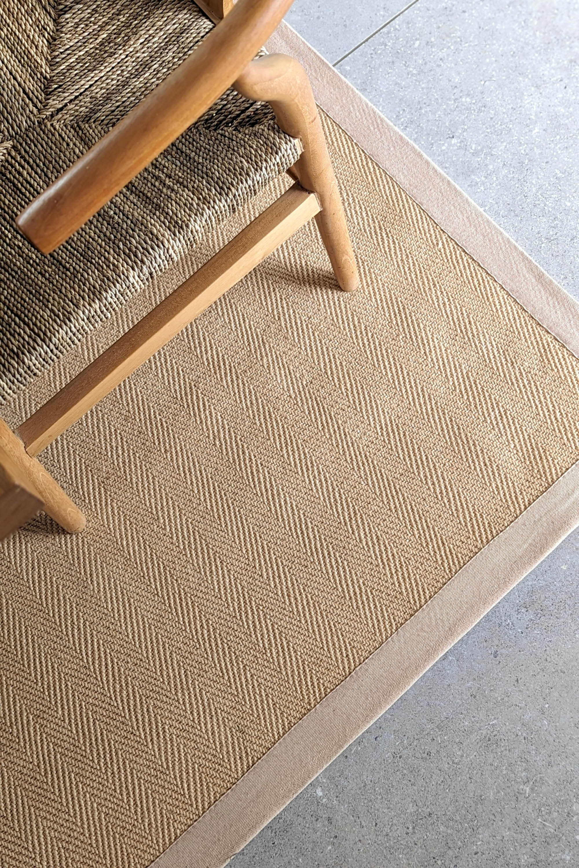 Sisal rug with herringbone pattern and beige linen border