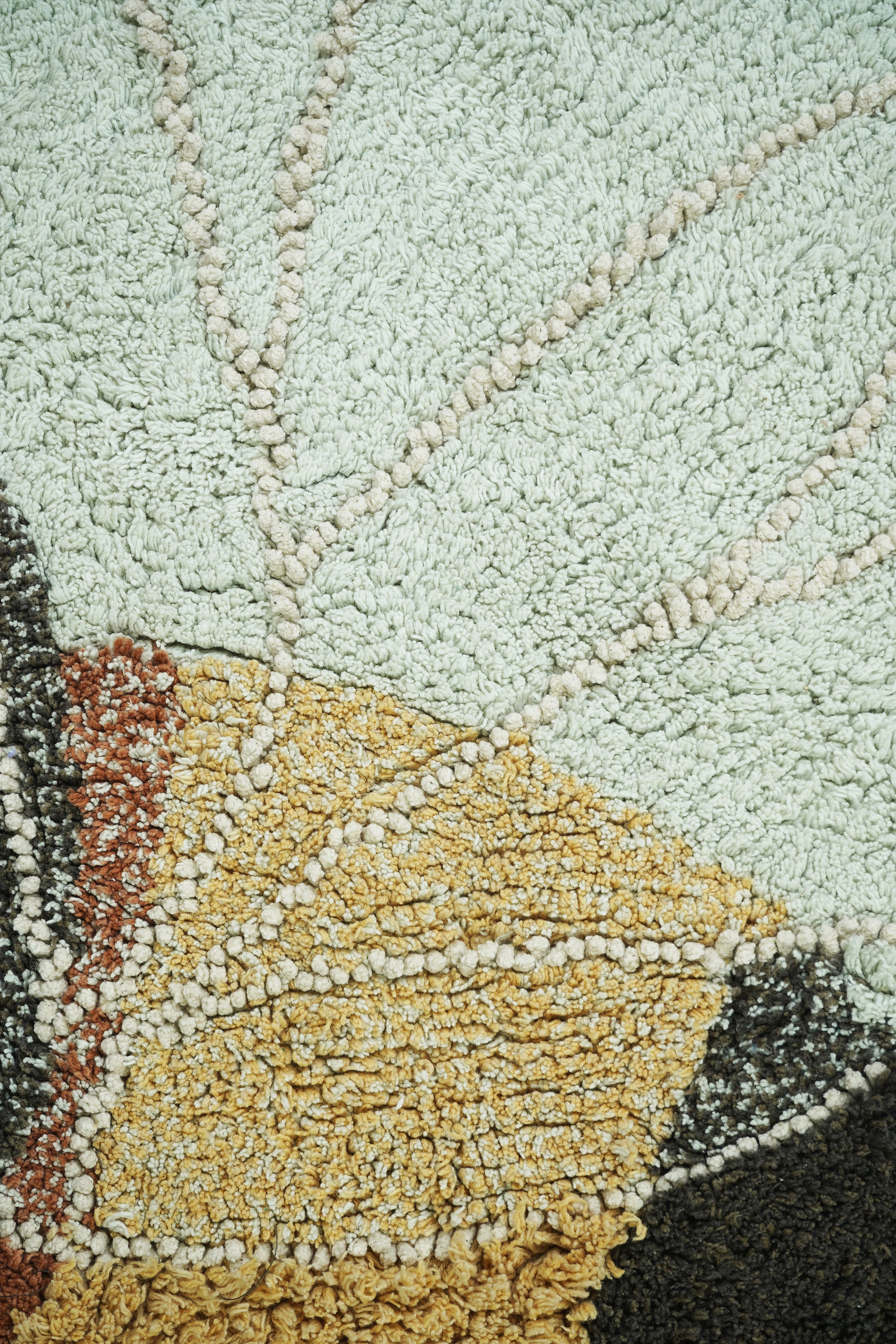 Bee-shaped rug with shades of gold, orange, brown, cream, and beige
