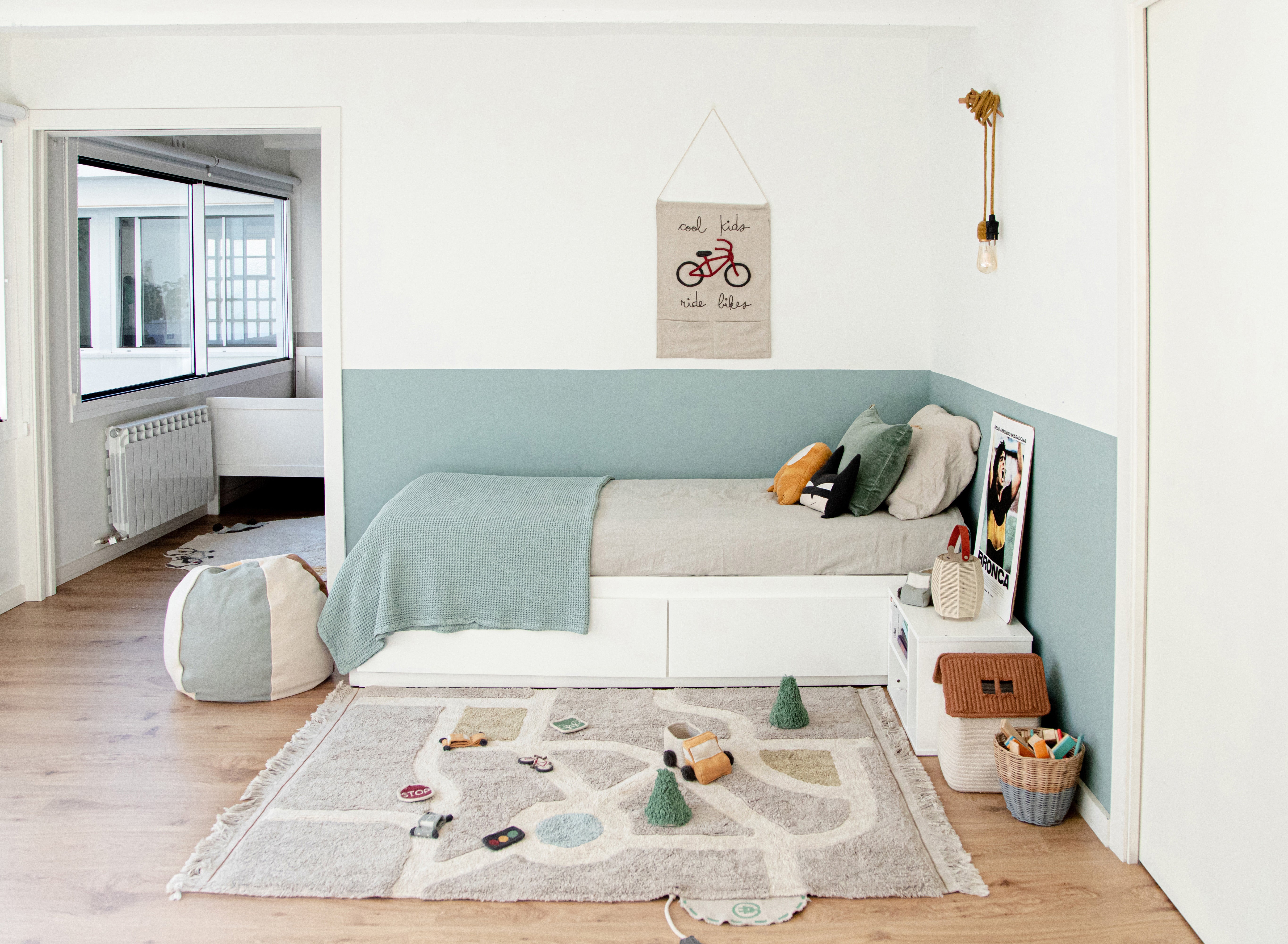 Grey, cream, blue, and green rug with city plan pattern and added city toys