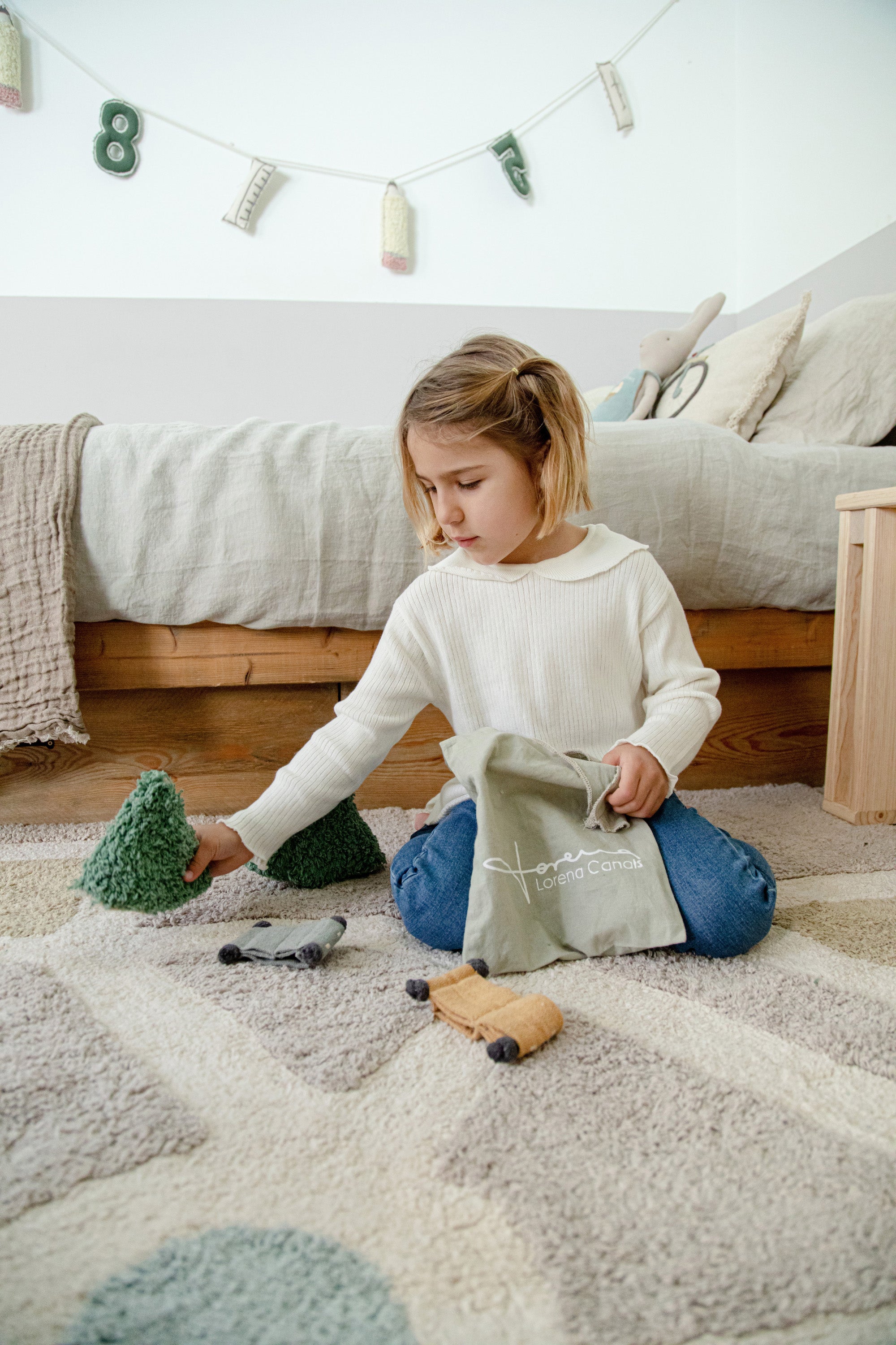 Grey, cream, blue, and green rug with city plan pattern and added city toys