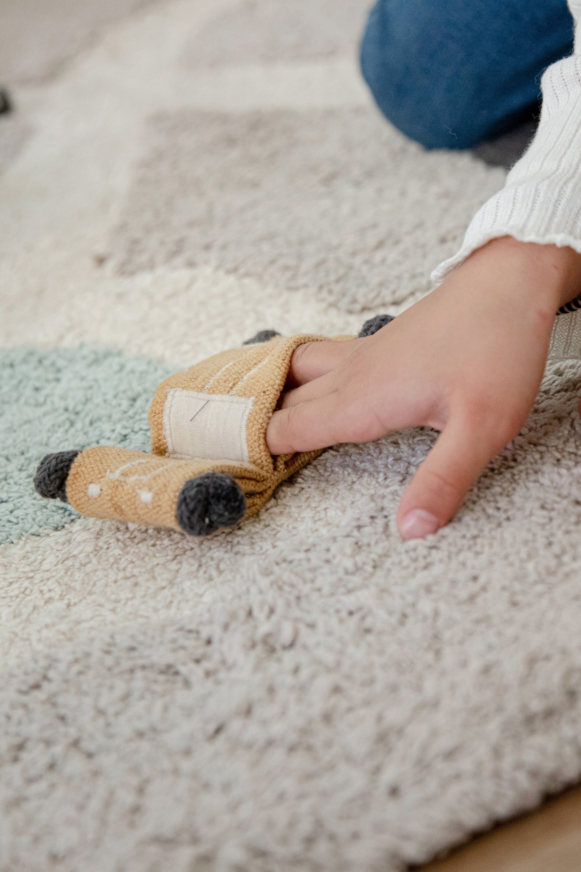 Grey, cream, blue, and green rug with city plan pattern and added city toys