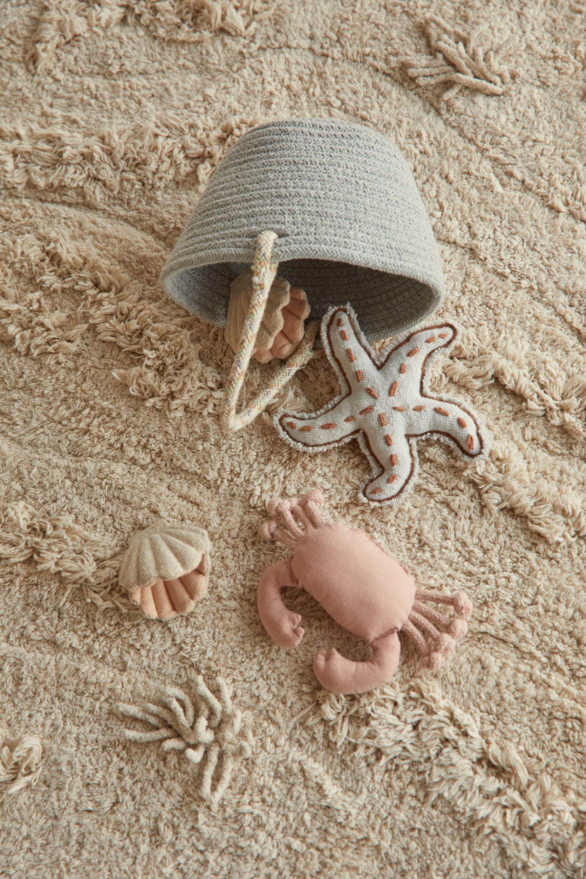 Beige island inspired rug with green fringing and added beach toys