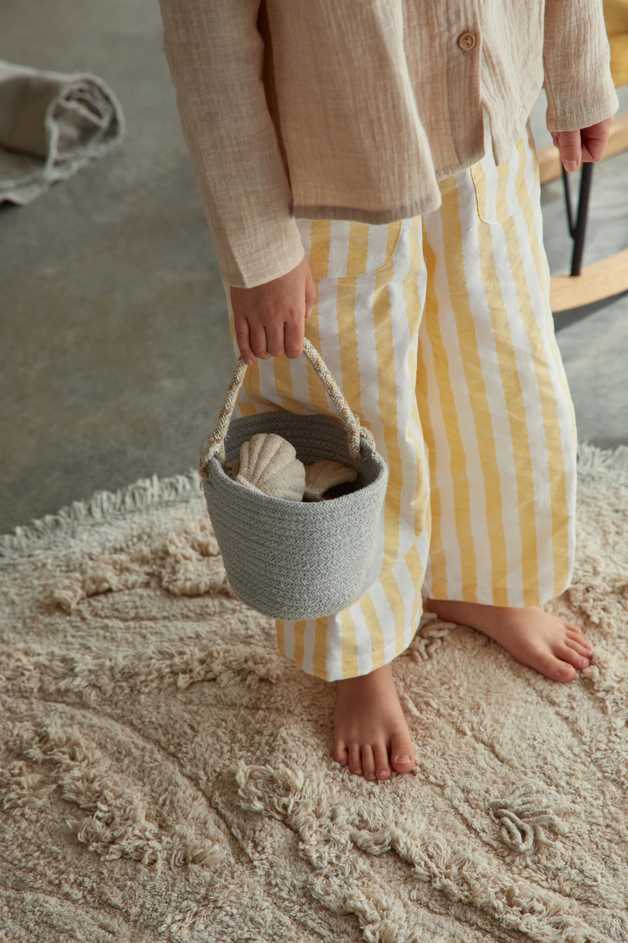 Beige island inspired rug with green fringing and added beach toys