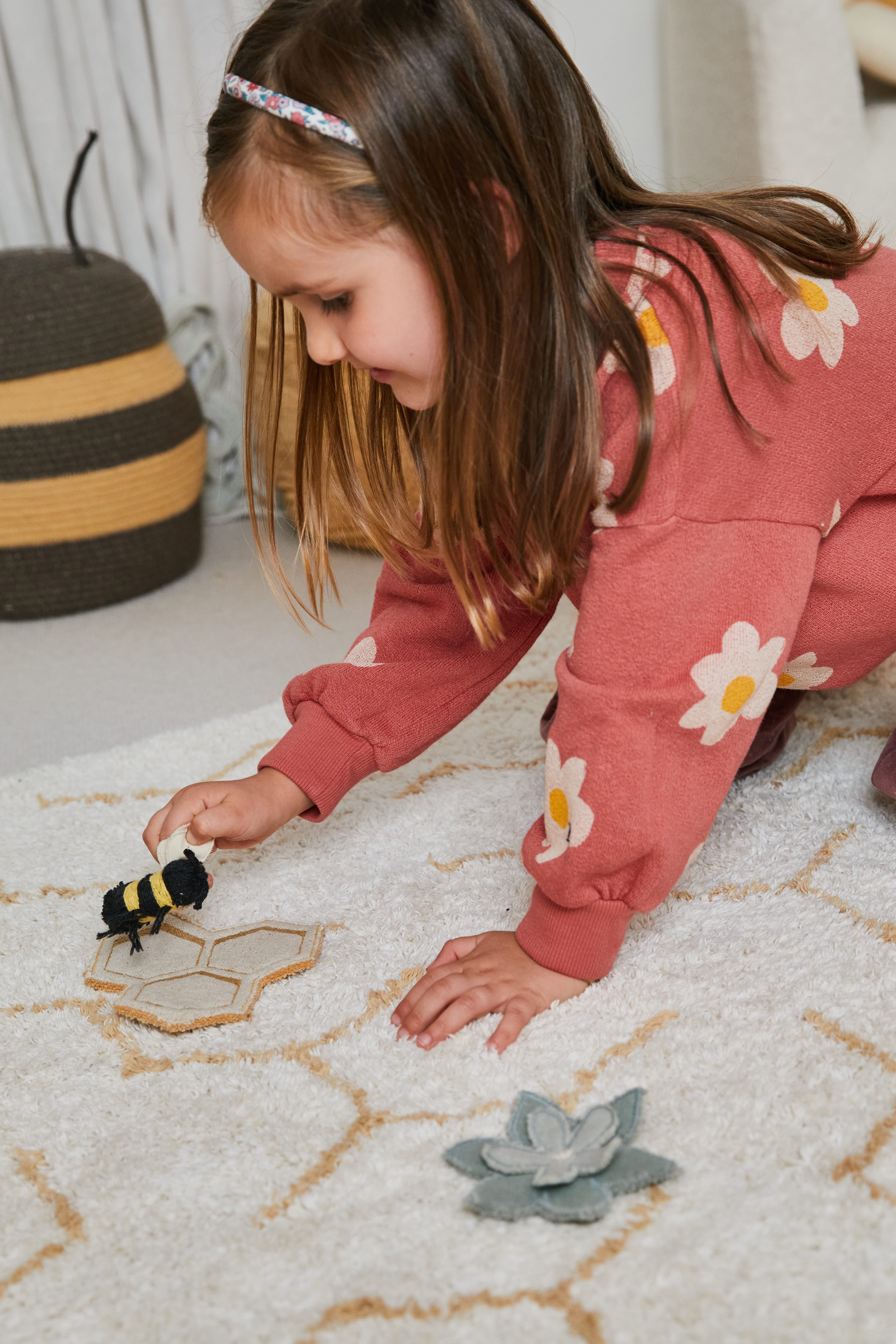 Cream rug with minimal yellow honeycomb pattern and honeybee toys