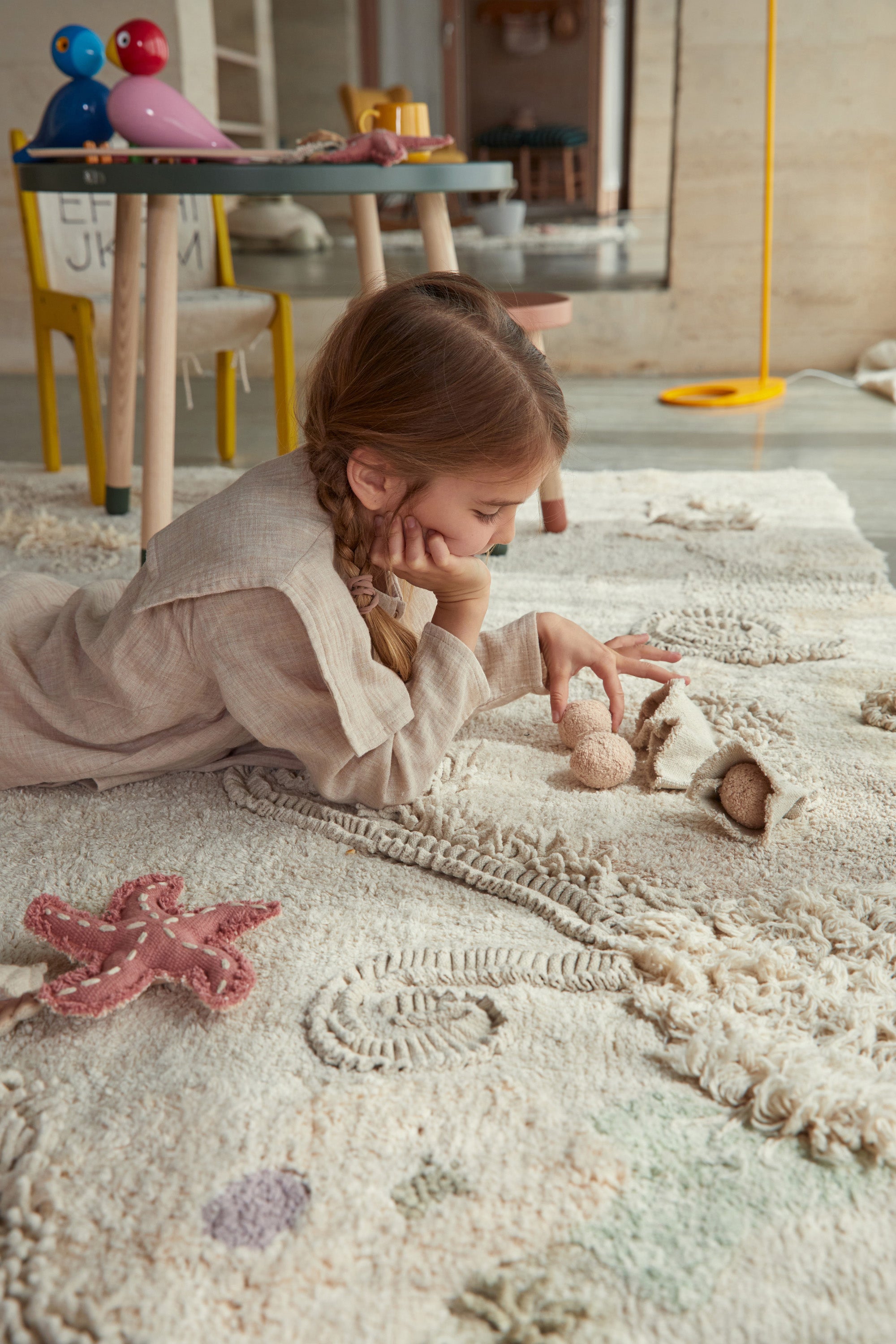 Cream seabed-inspired rug with added sea creature toys