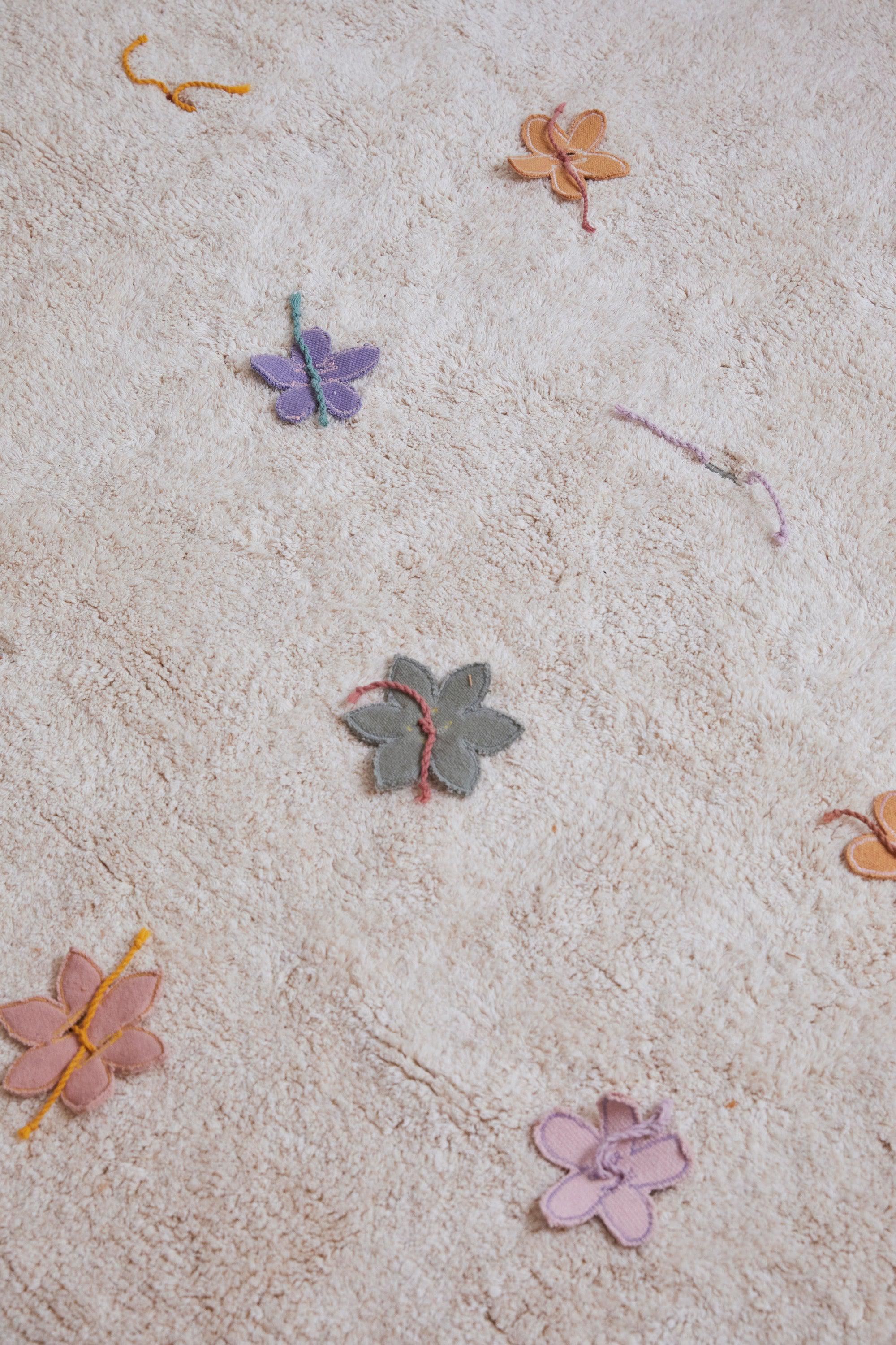 Plain cream rug with multicolour lined pattern and added wildflower toys