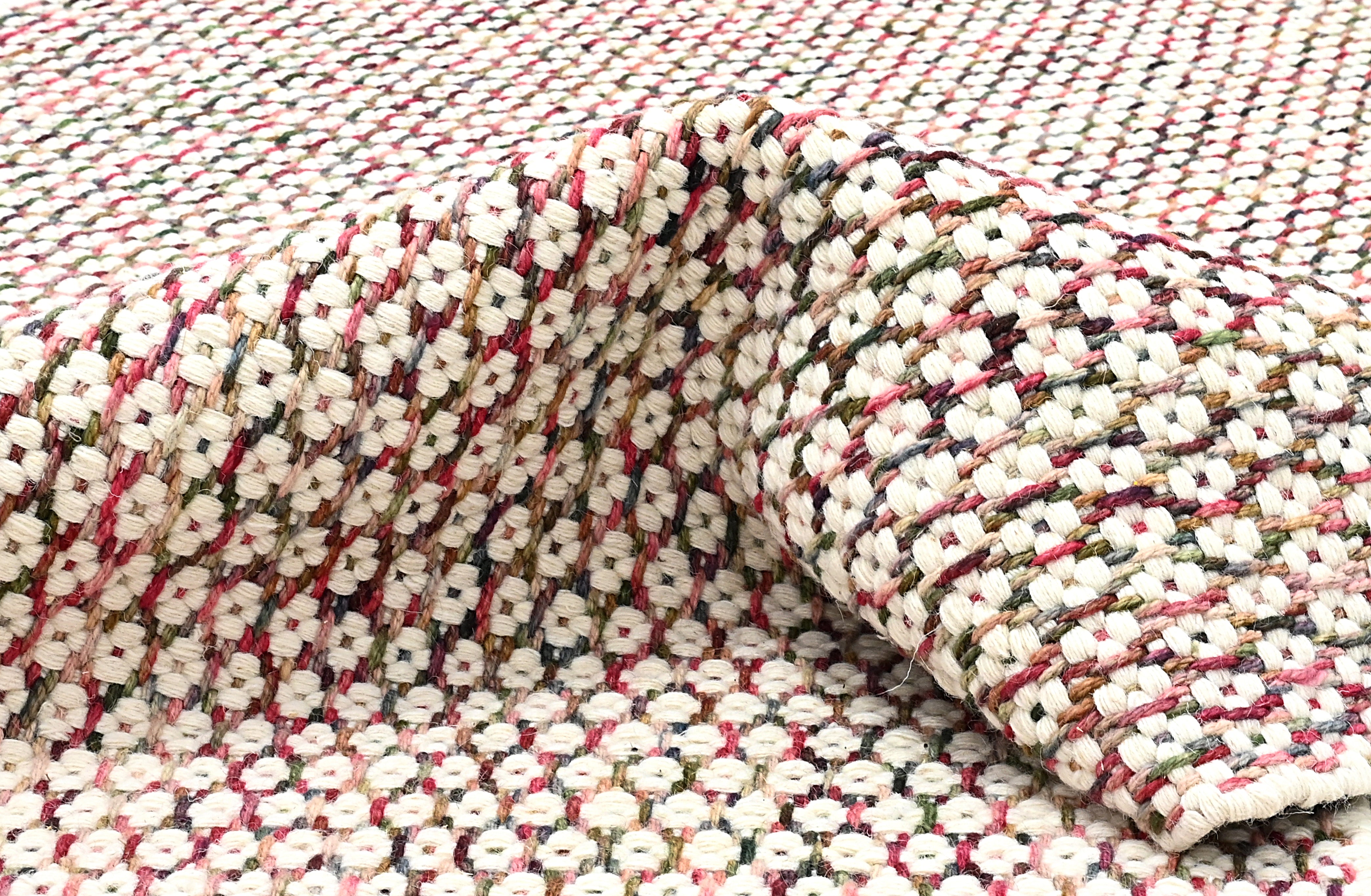 Textured wool rug with pink, blue and green yarns throughout