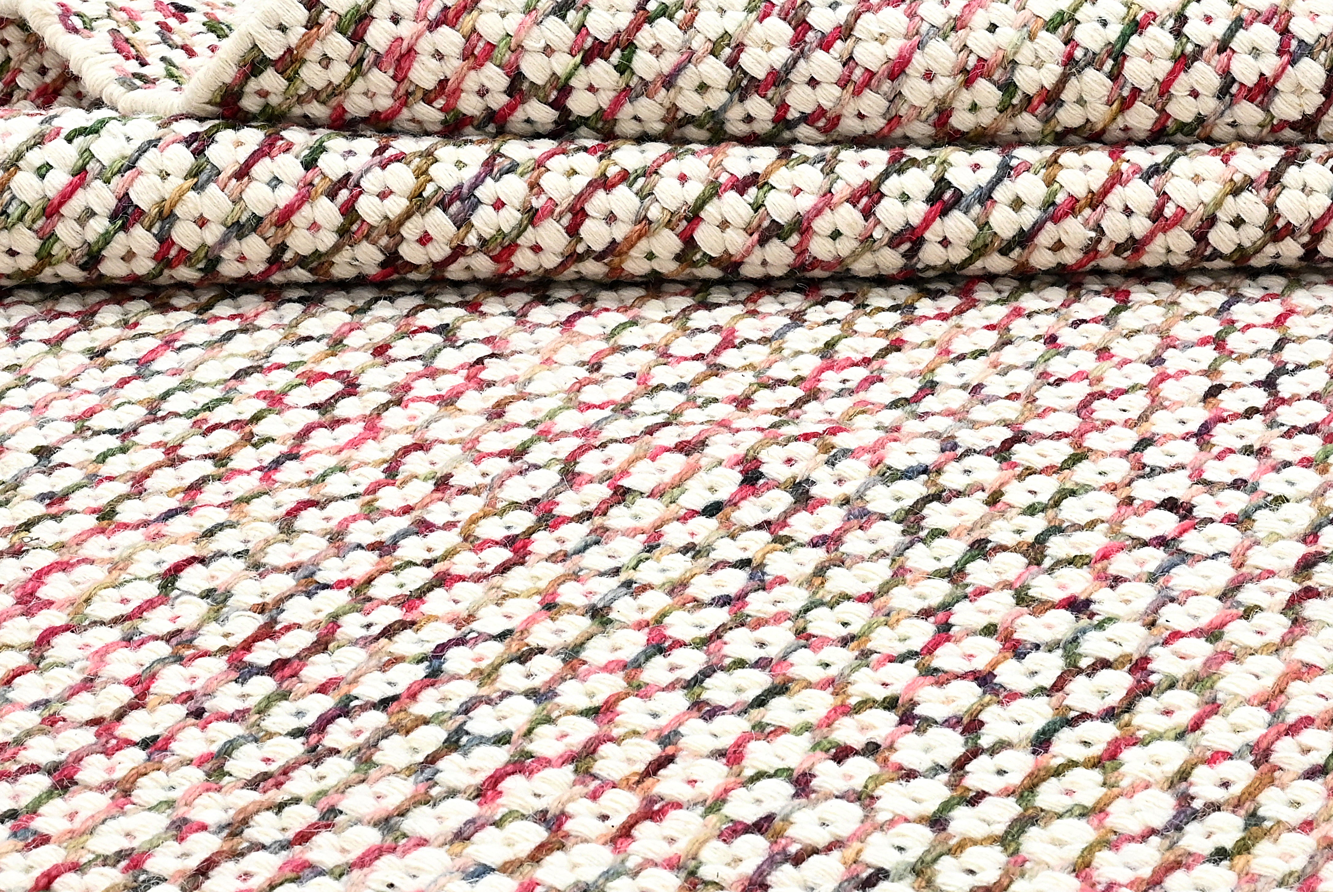 Textured wool rug with pink, blue and green yarns throughout