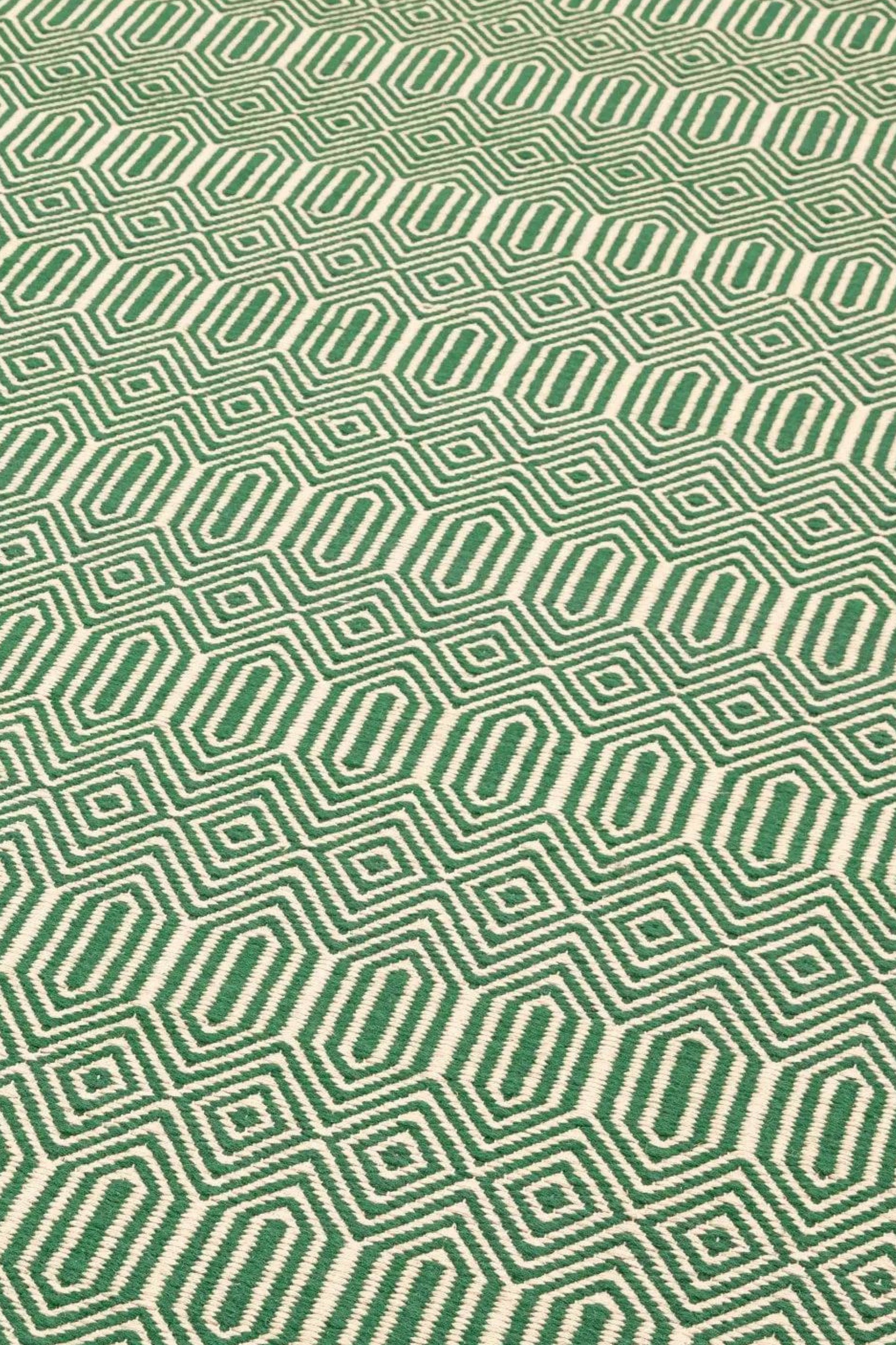 Green woven rug with aztec chevron pattern
