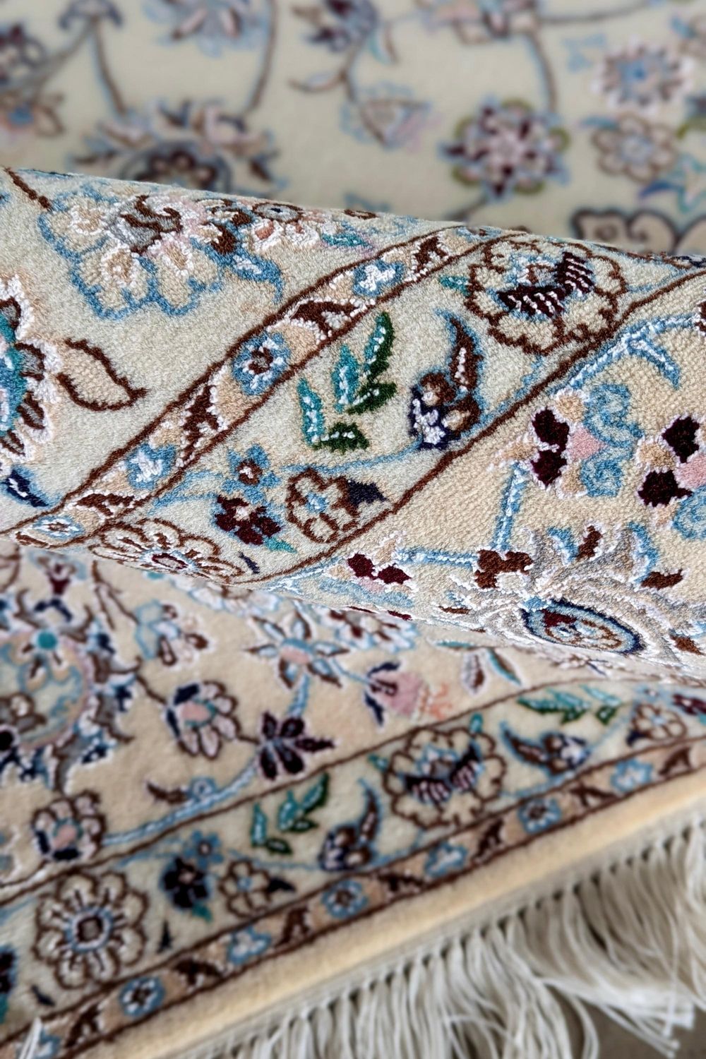 Authentic oriental rug with traditional floral design in cream, ivory and blue