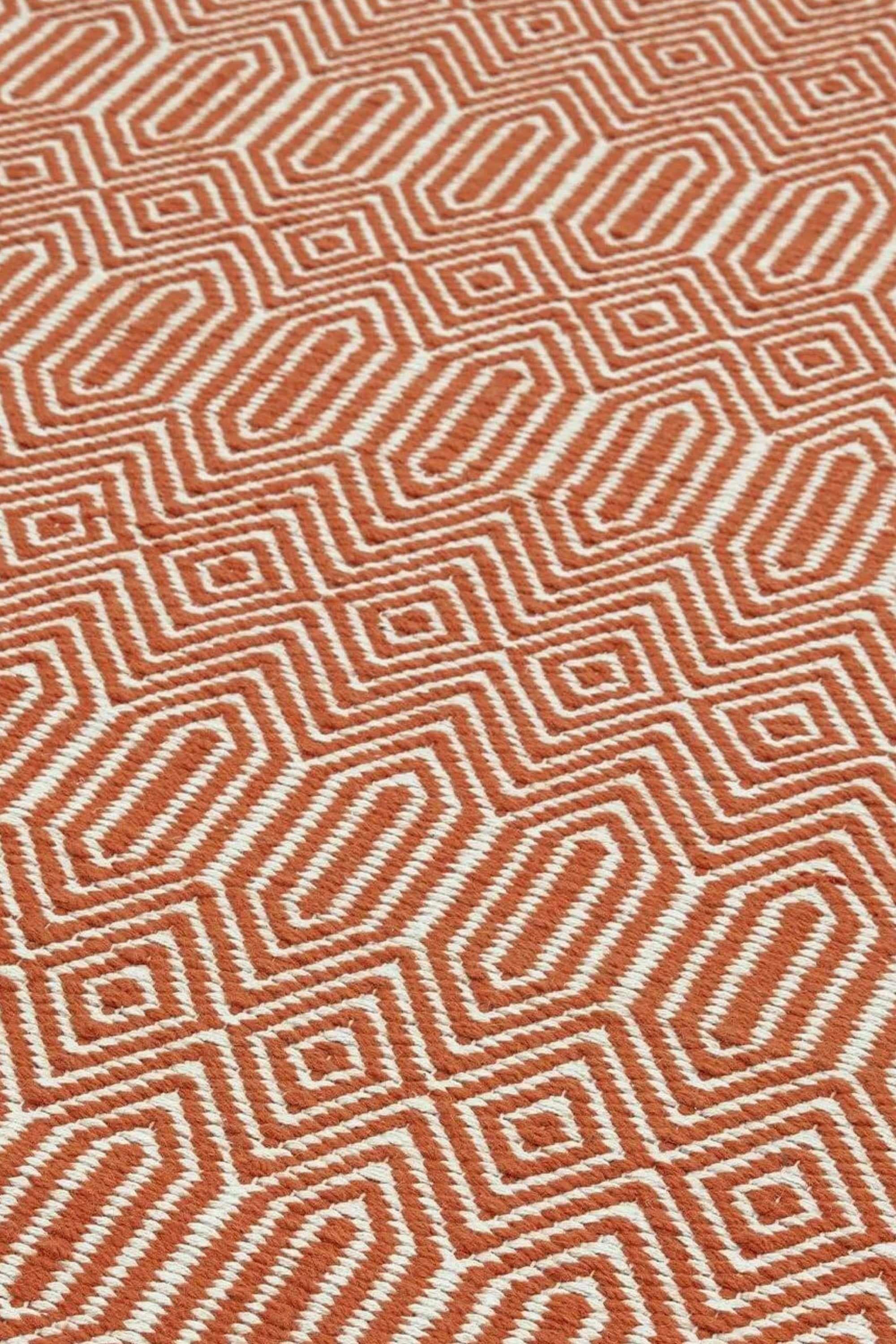 orange and white geometric runner with an aztec pattern