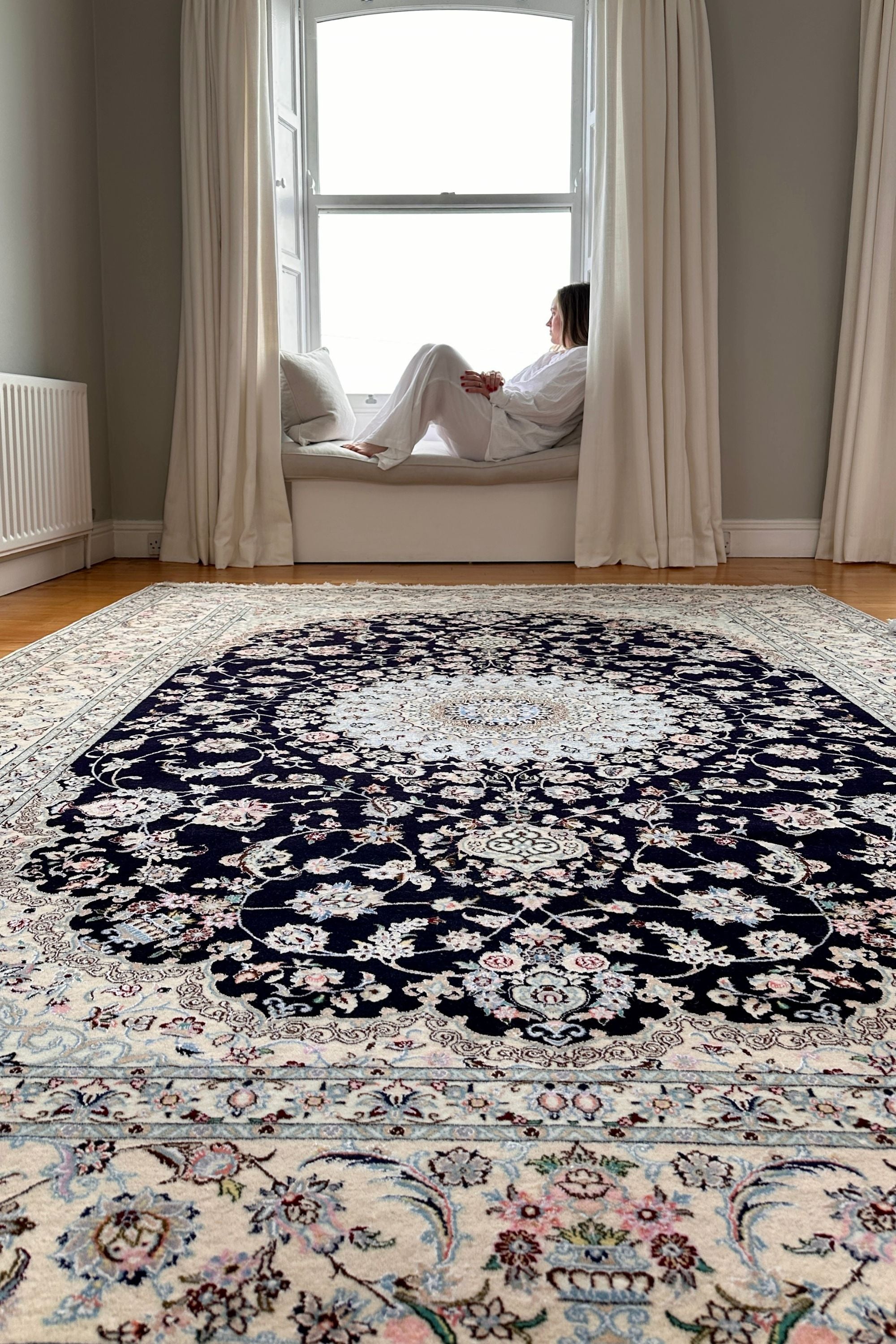 Authentic oriental rug with traditional floral design in cream, navy, blue and pink