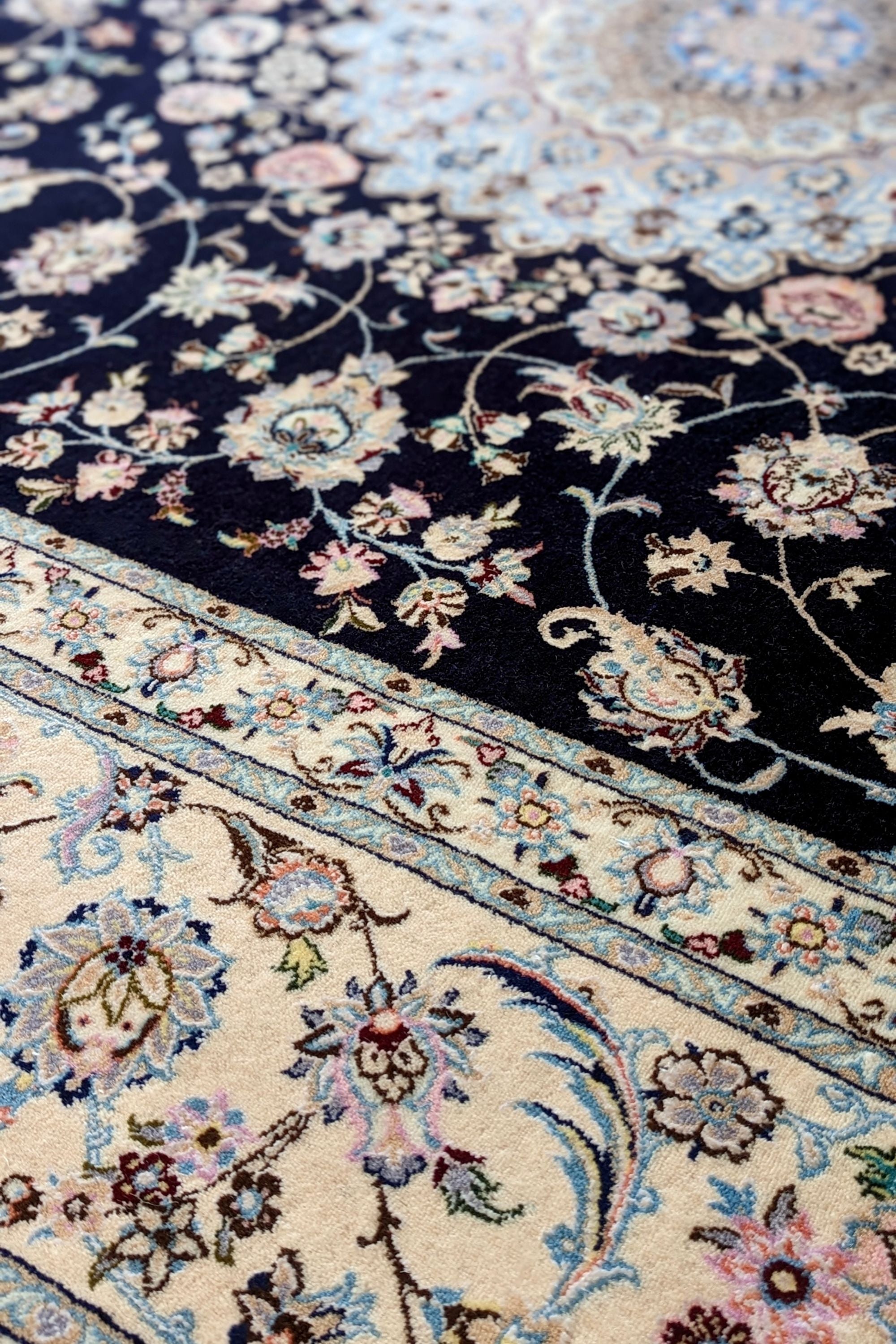 Authentic oriental rug with traditional floral design in cream, navy, blue and pink