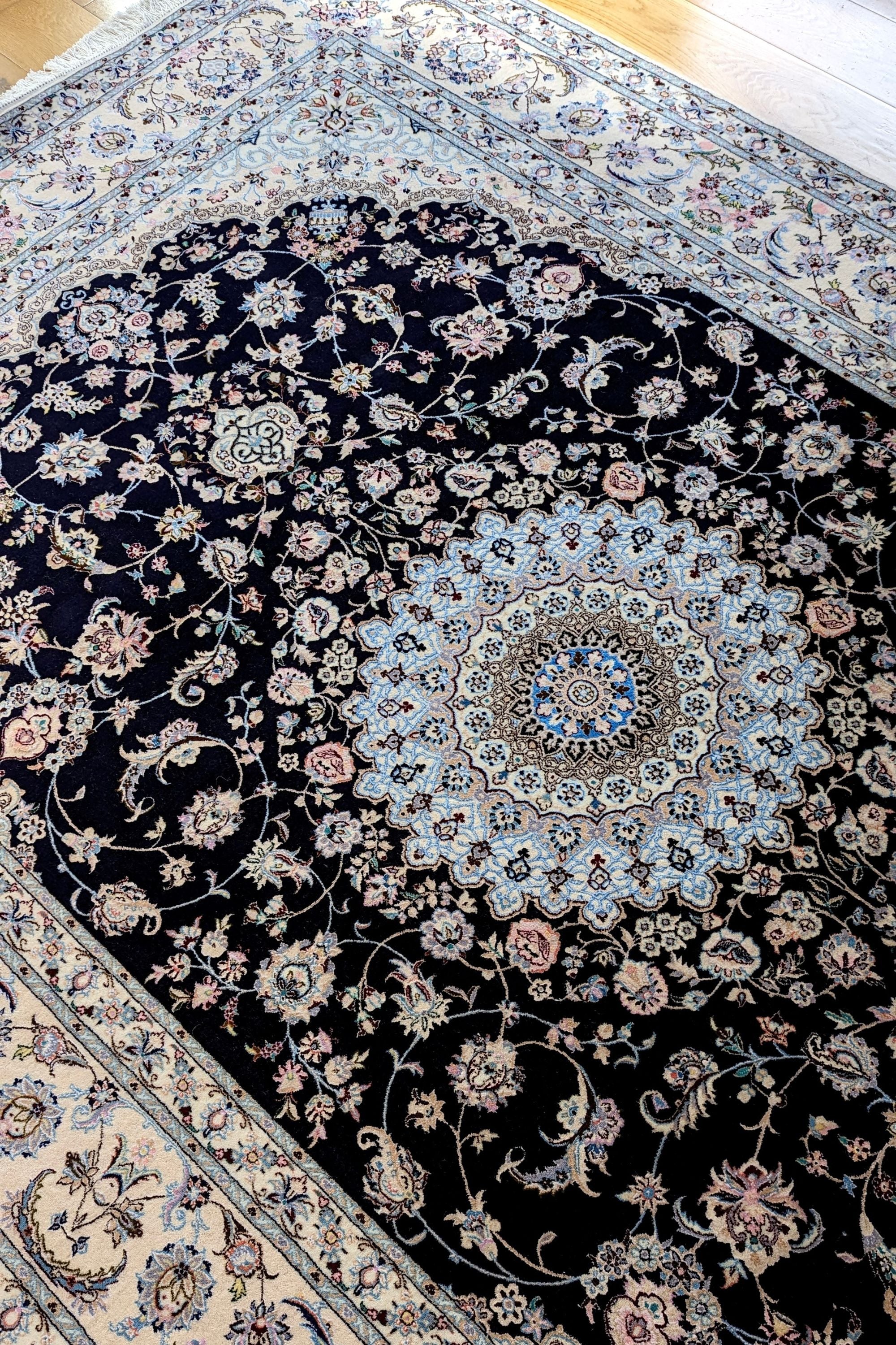 Authentic oriental rug with traditional floral design in cream, navy, blue and pink