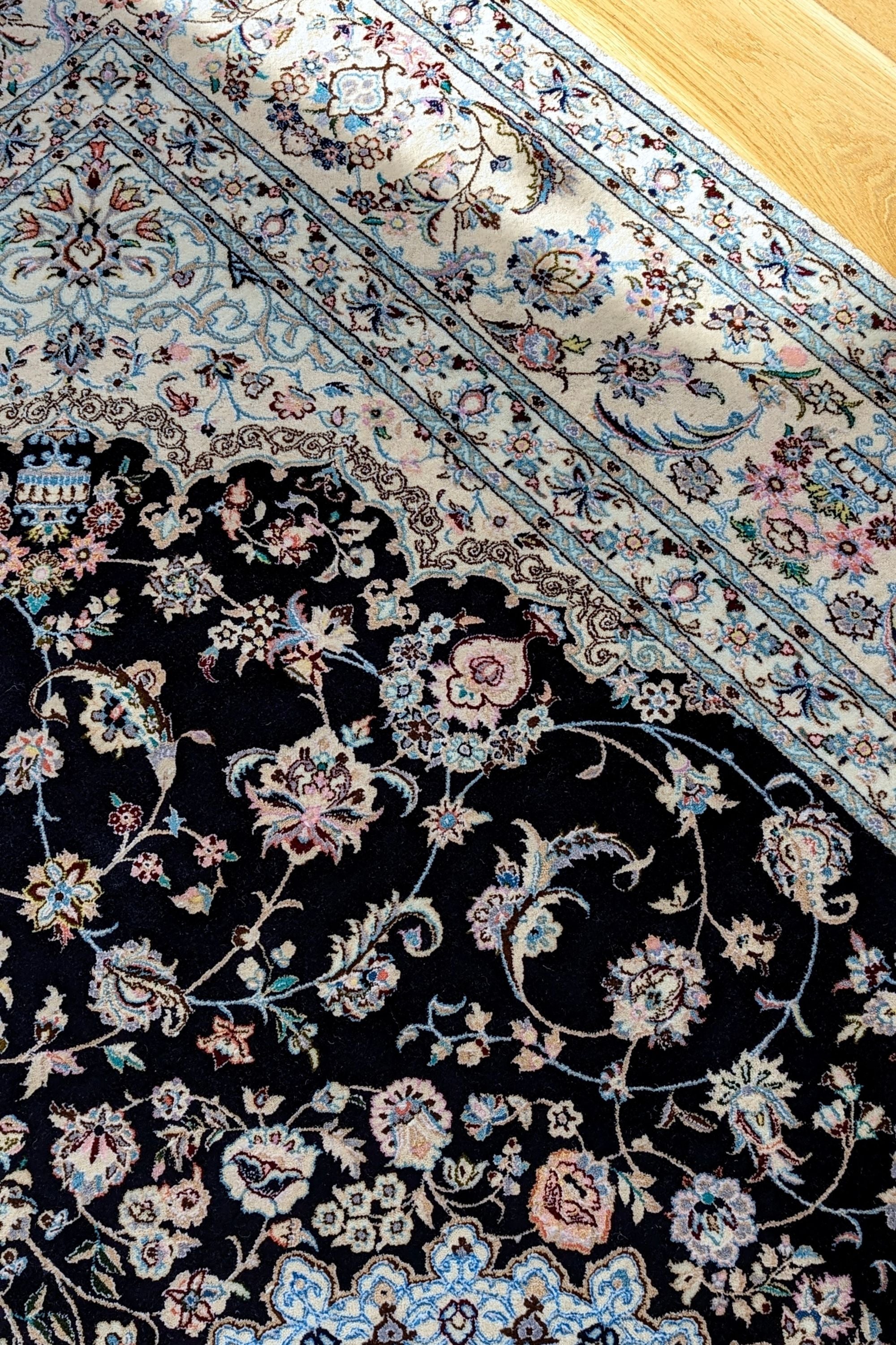Authentic oriental rug with traditional floral design in cream, navy, blue and pink