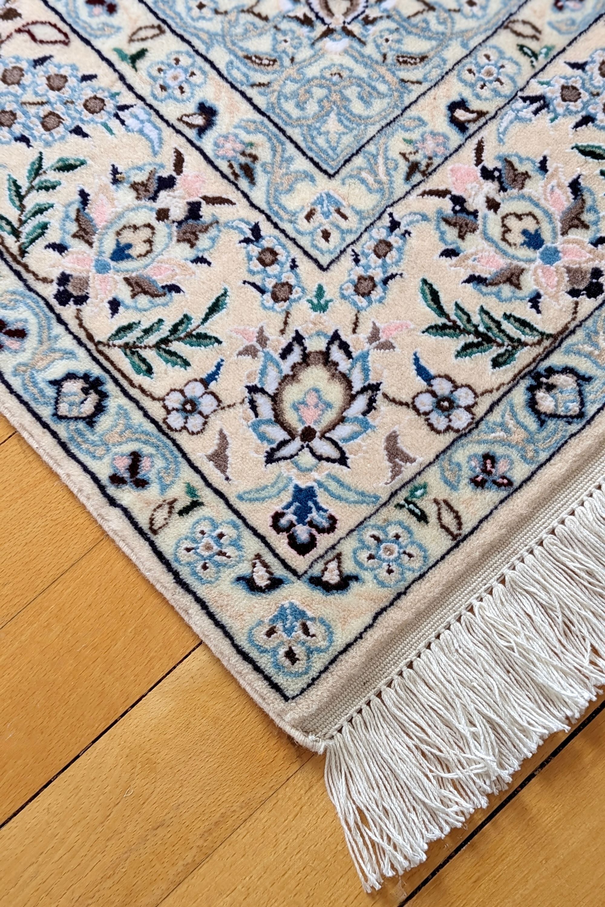 Cream Nain Persian rug with blue and red floral pattern
