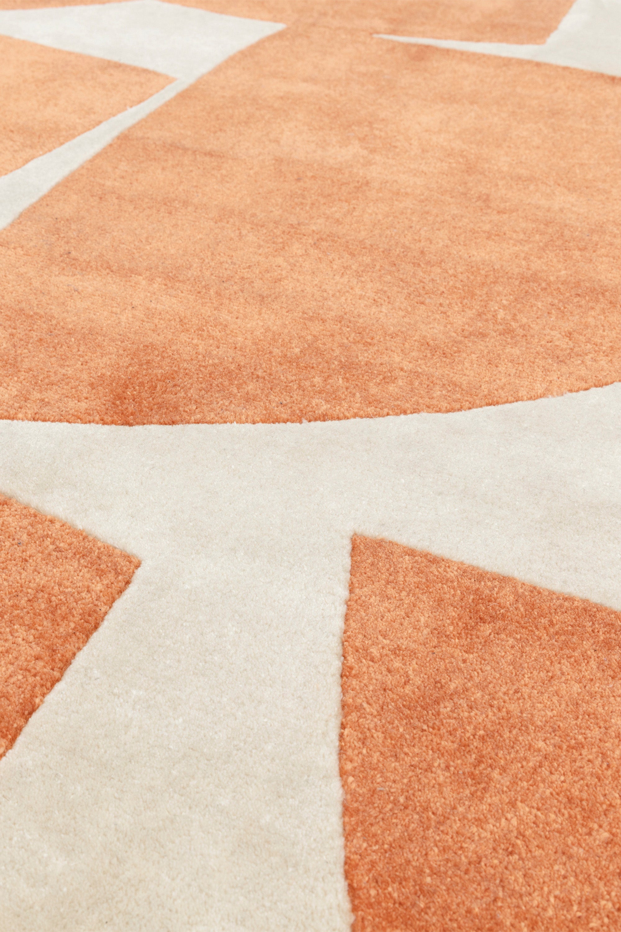 Orange and cream rug with abstract pattern