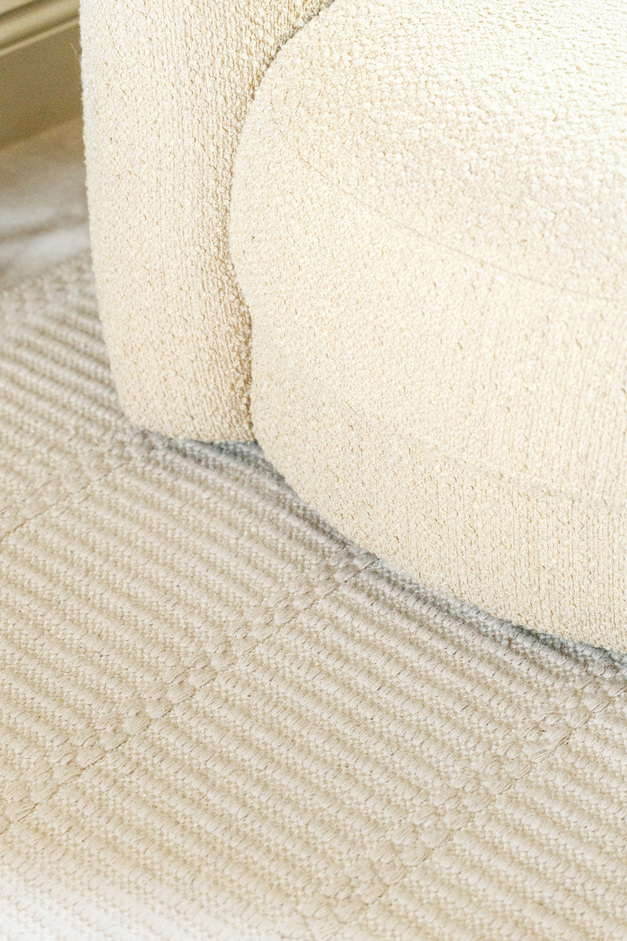 beige wool and cotton rug featuring a design inspired by ancient irish script placed under a couch