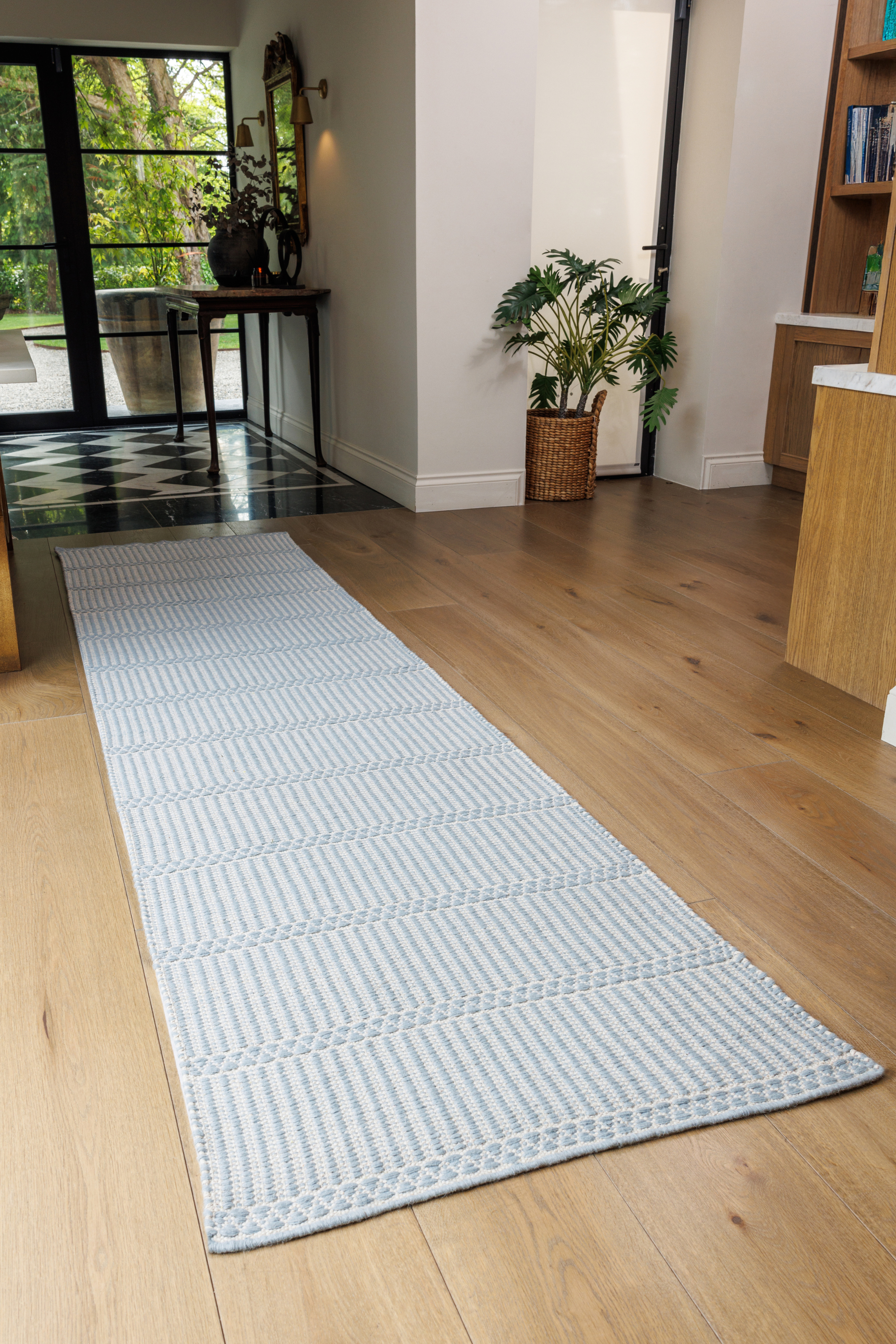 Blue wool and cotton runner rug featuring a design inspired by ancient irish script placed in a hallway