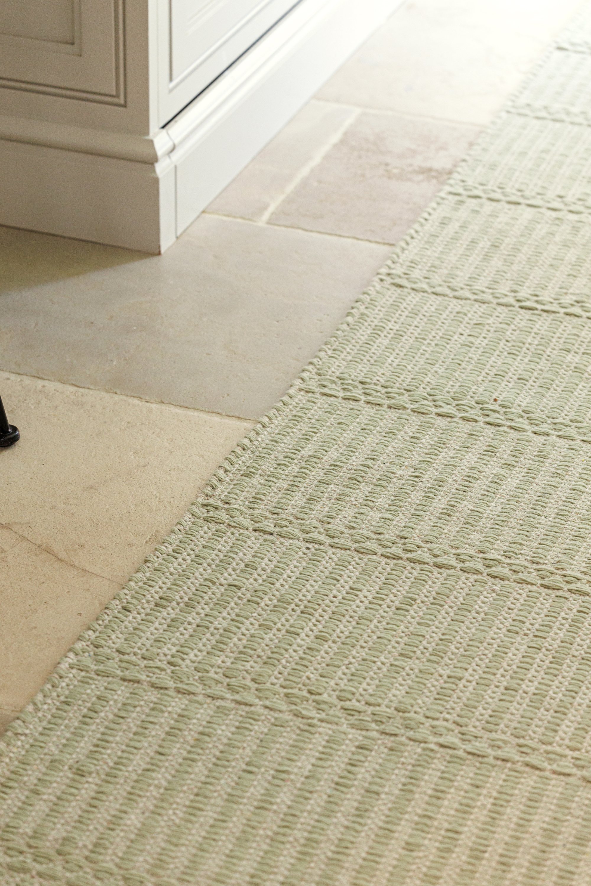 wool and cotton runner rug in soft olive hues featuring a design inspired by ancient irish script