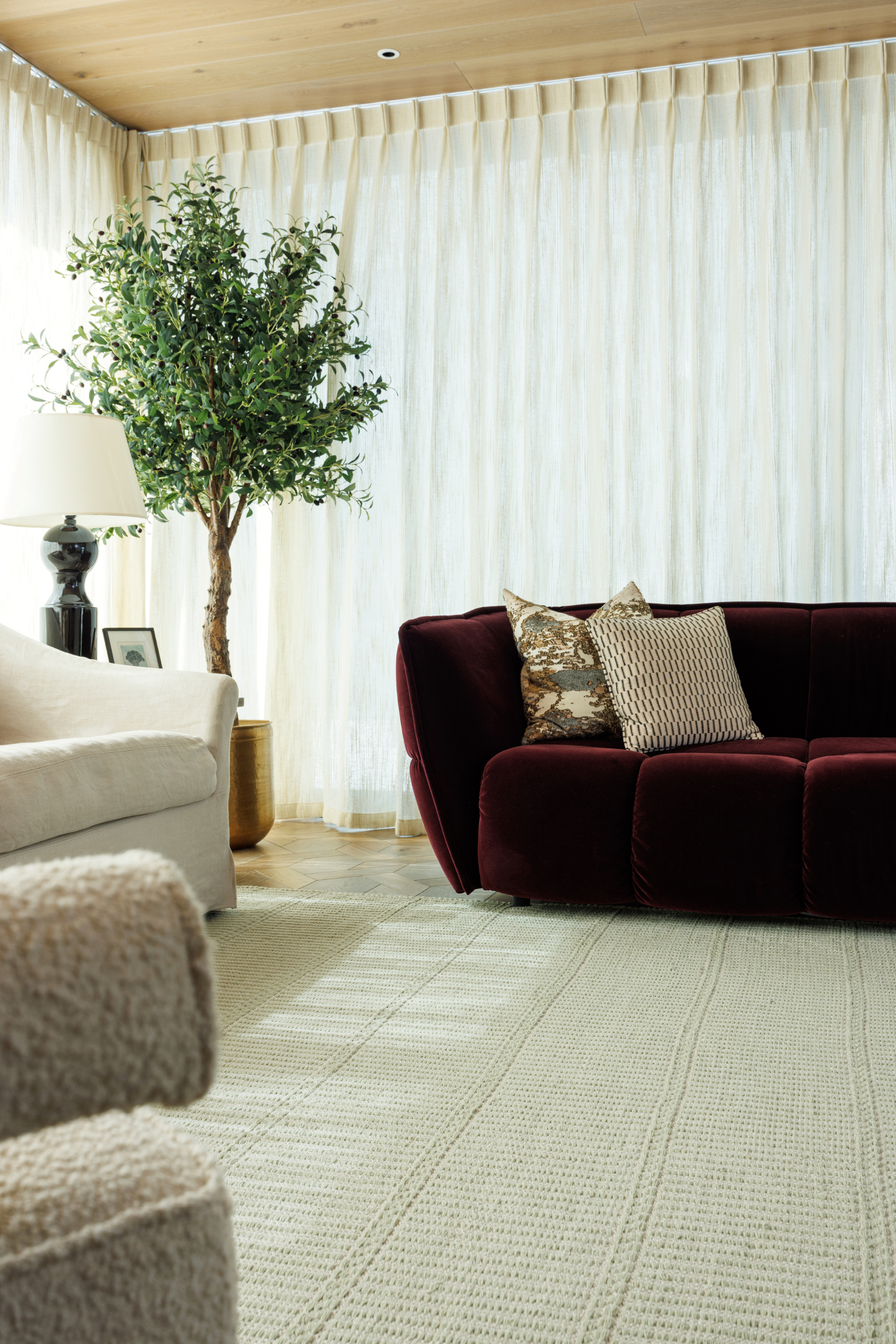 wool and cotton rug in soft olive hues featuring a design inspired by ancient irish script placed under a couch in a living room