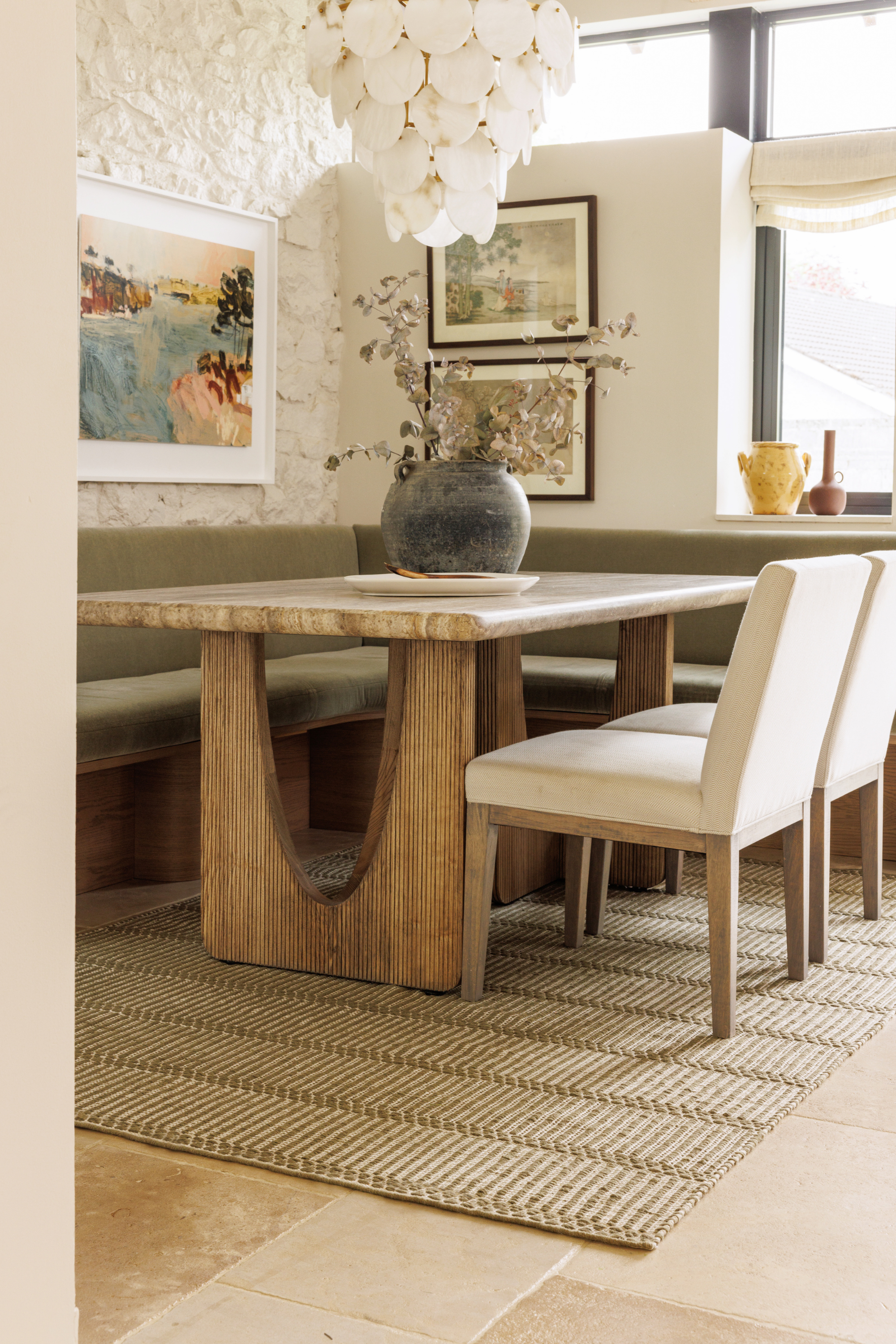 wool and cotton rug in dark green moss tones featuring a design inspired by ancient irish script placed under a dining table