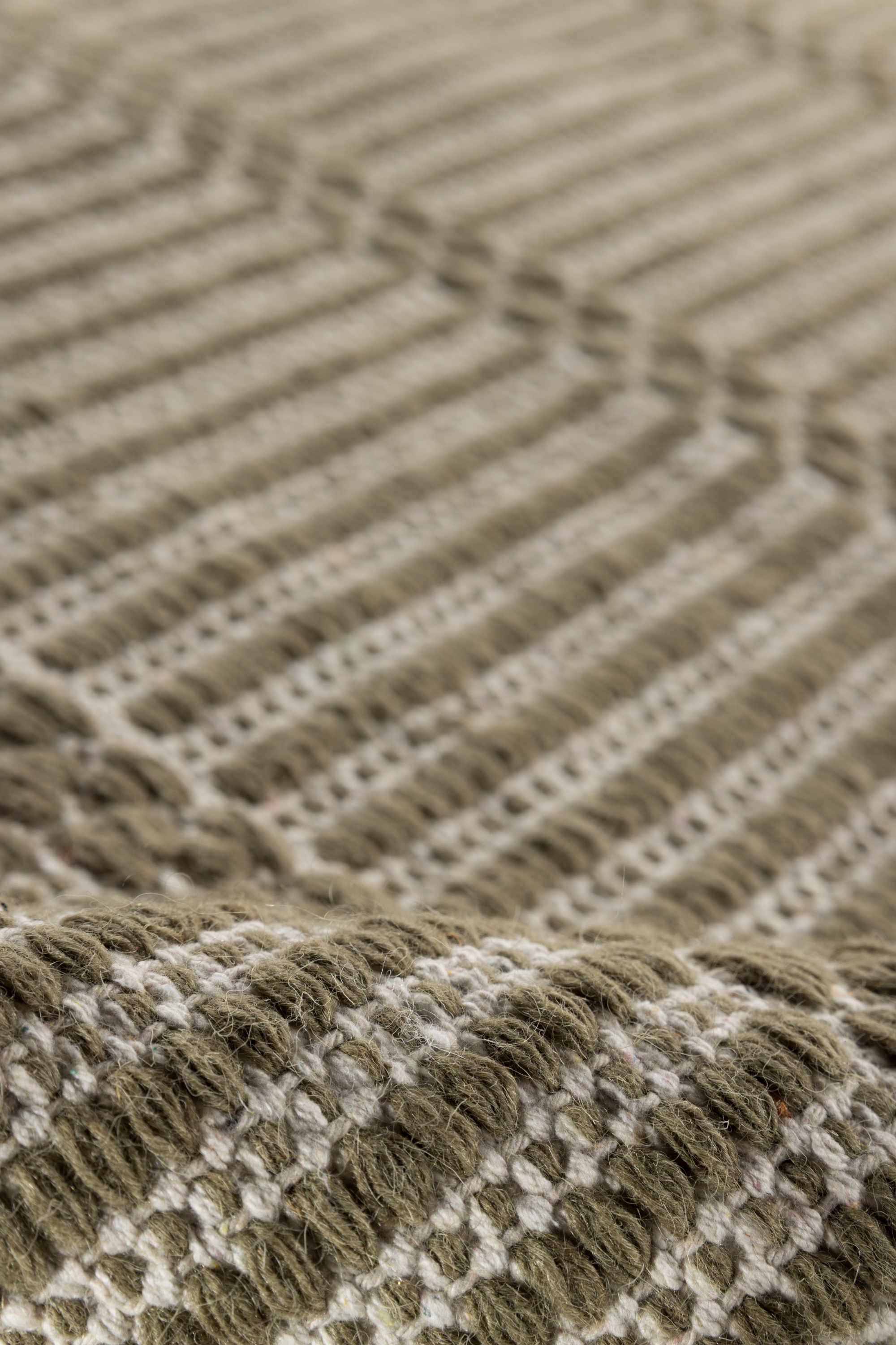 wool and cotton runner rug in dark green moss tones featuring a design inspired by ancient irish script