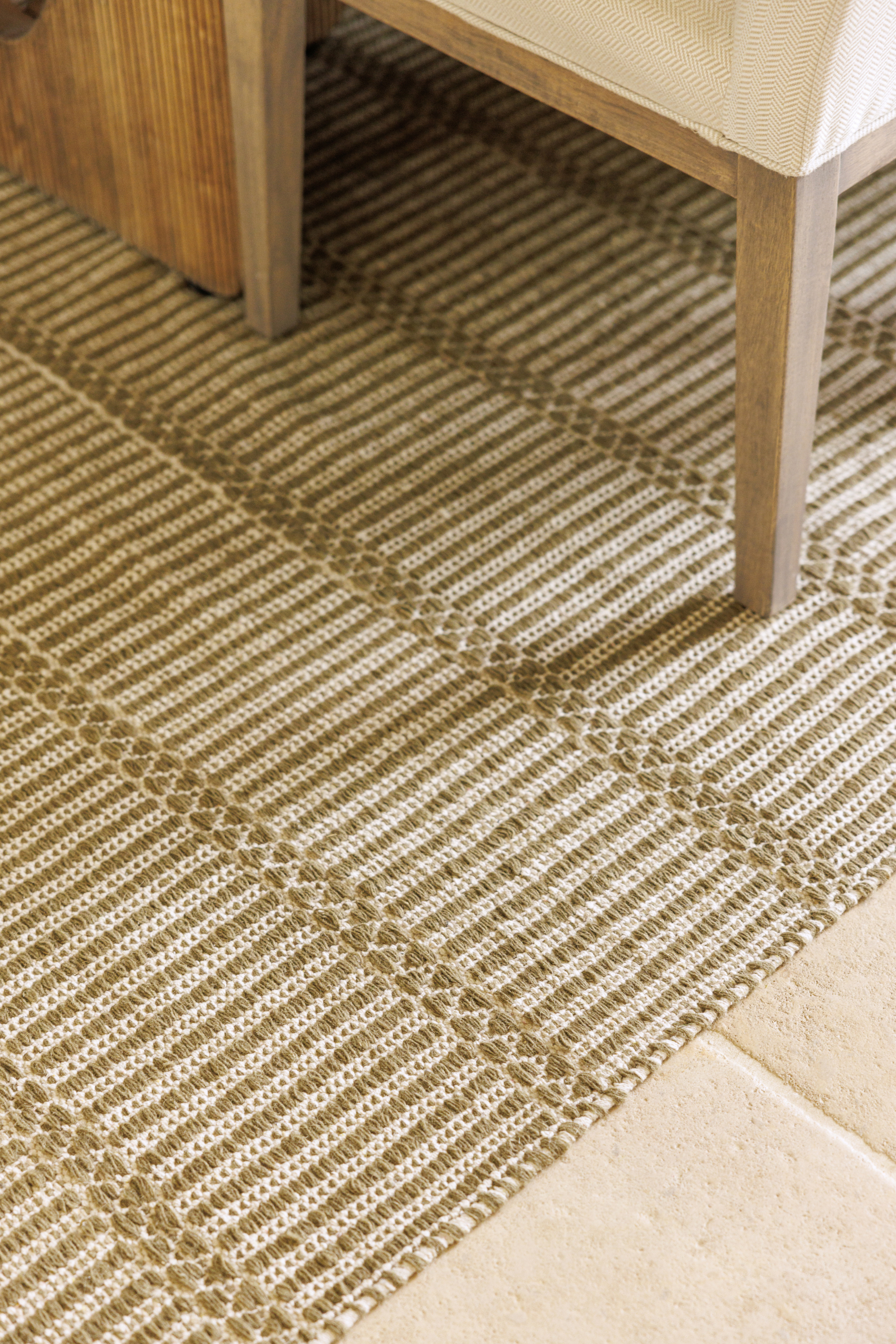 wool and cotton rug in dark green moss tones featuring a design inspired by ancient irish script