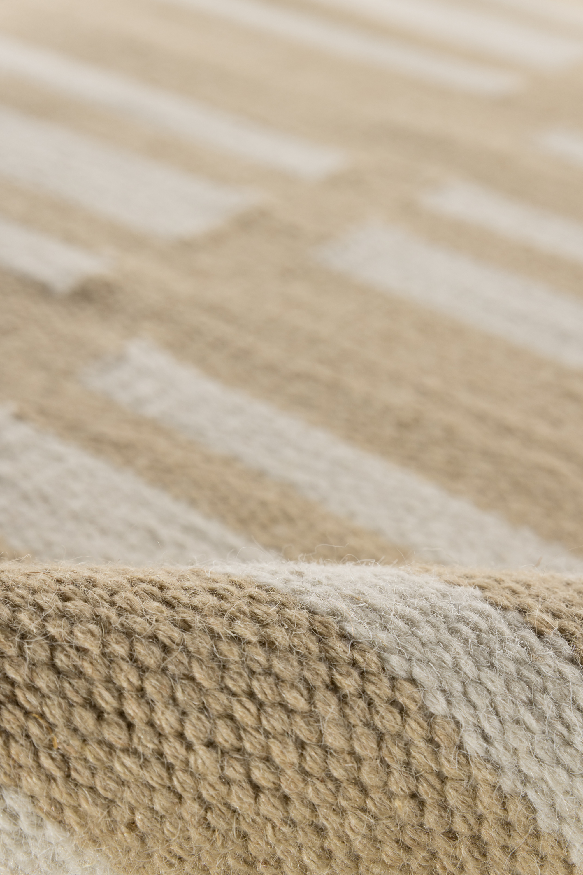 beige and straw toned wool and cotton rug featuring an irregular linear pattern