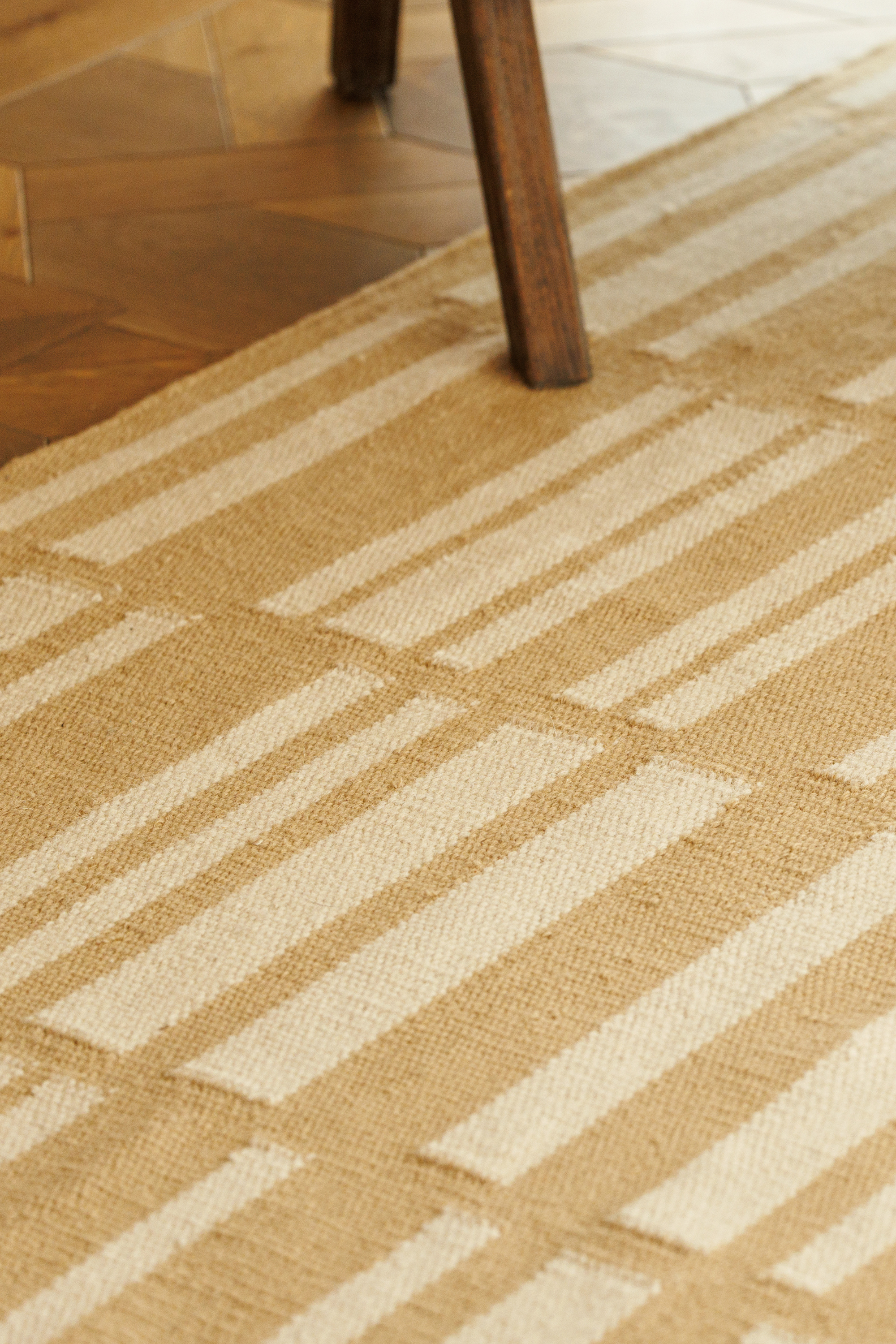 beige and straw toned wool and cotton rug featuring an irregular linear pattern