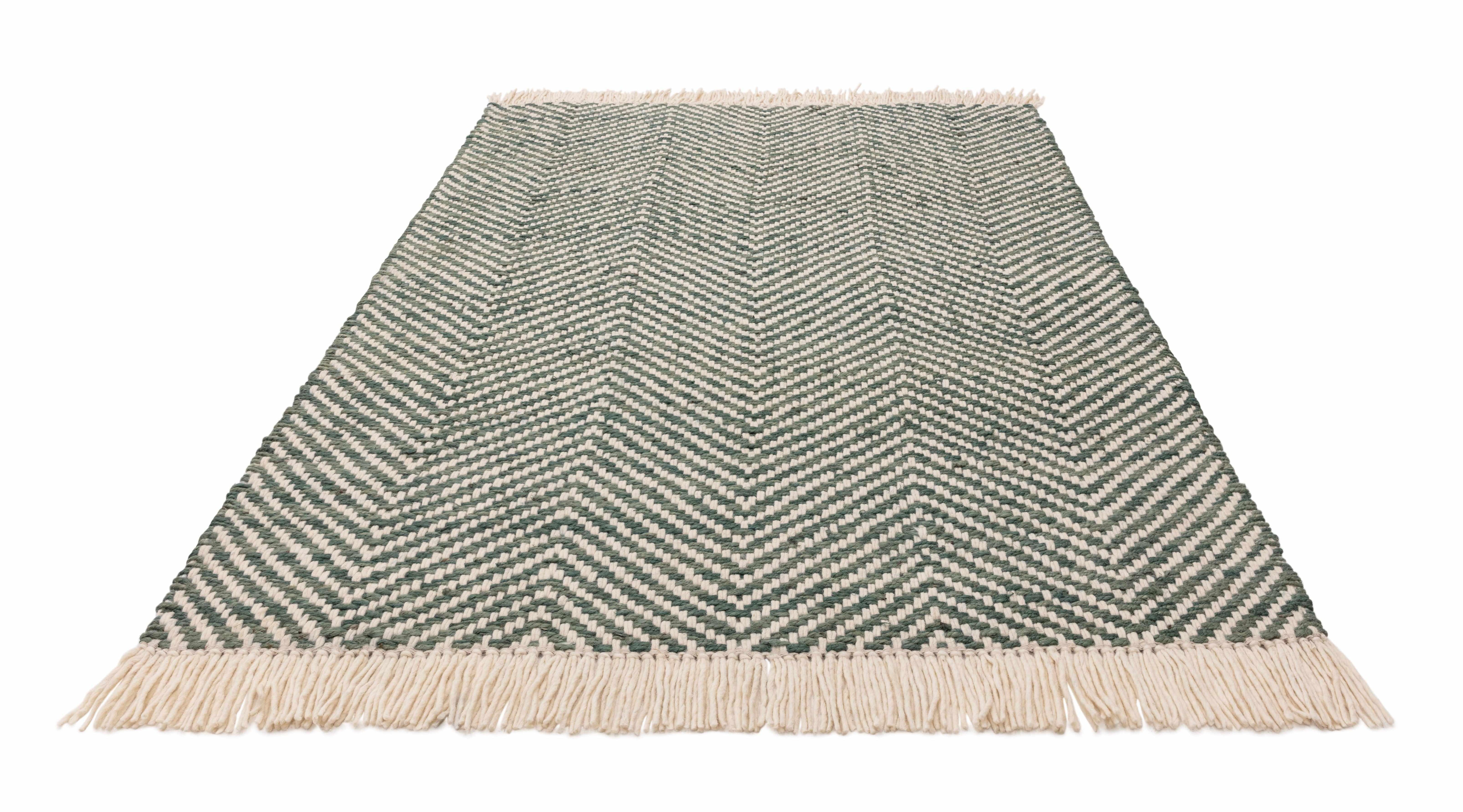 Textured woven rug with green and cream chevron pattern
