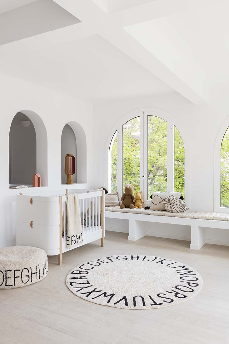 Circular white cotton rug decorated with a black alphabet border