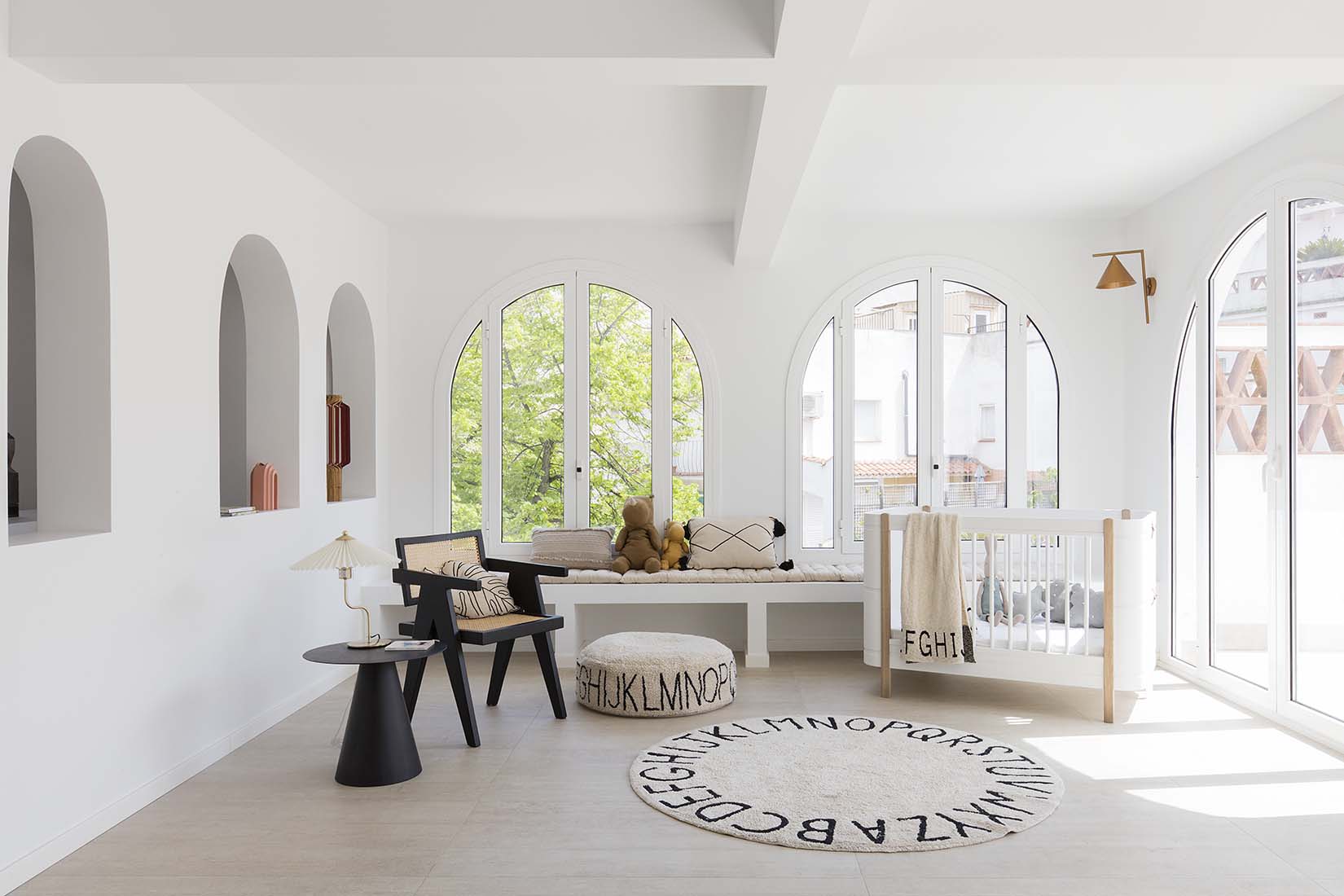 Circular white cotton rug decorated with a black alphabet border