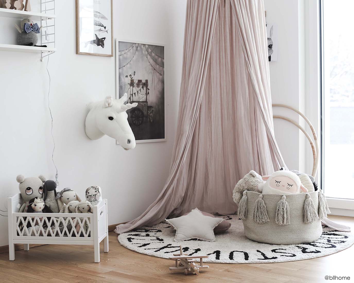 Circular white cotton rug decorated with a black alphabet border