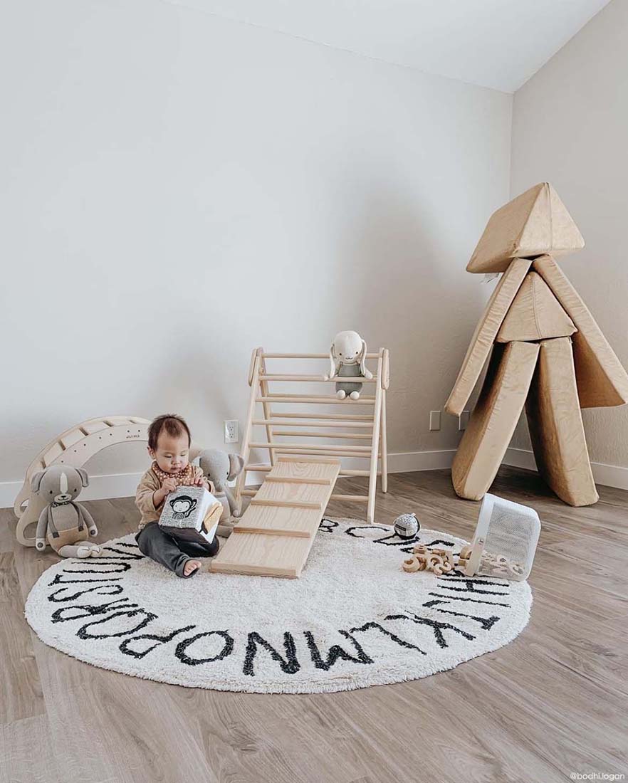 Circular white cotton rug decorated with a black alphabet border