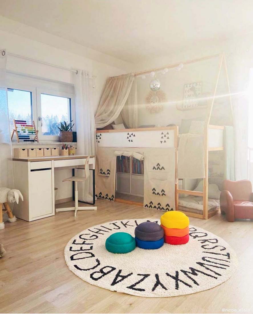 Circular white cotton rug decorated with a black alphabet border