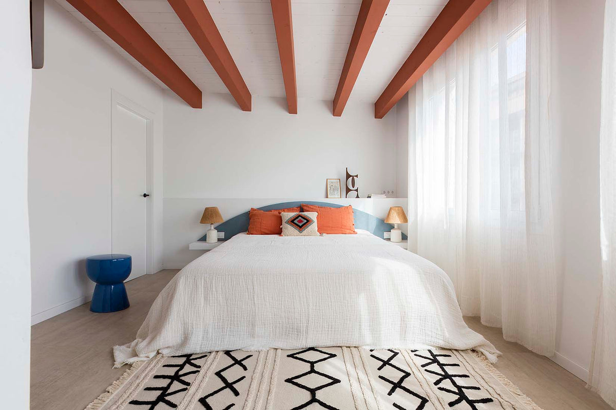 Rectangular beige cotton rug decorated with a black moroccan tribal design and a fringed border