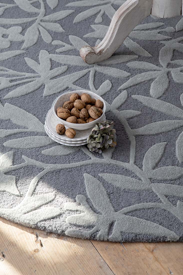 Grey wool circle rug with hand carved floral motifs
