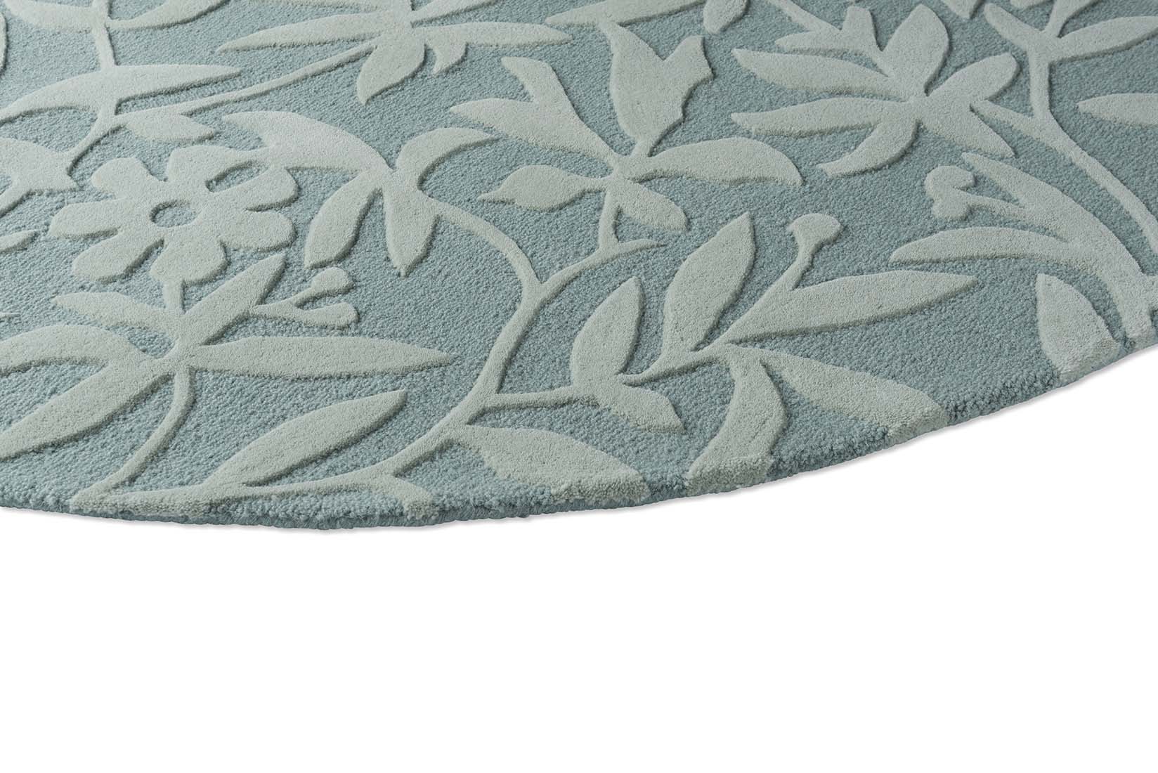 Green and blue wool circular rug with hand carved floral motifs
