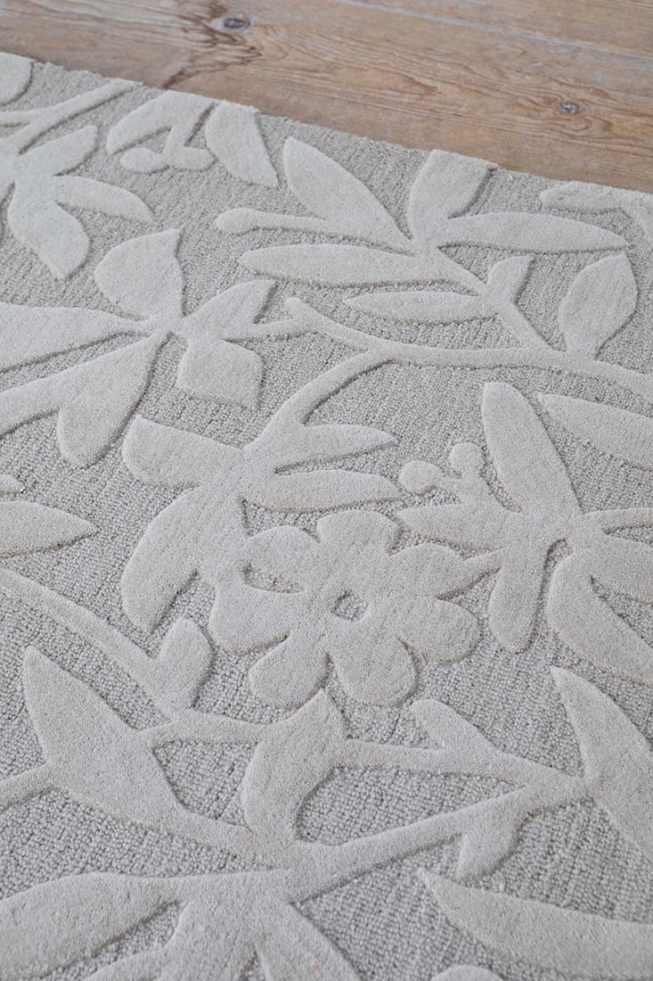 Beige wool rug with hand carved floral motifs
